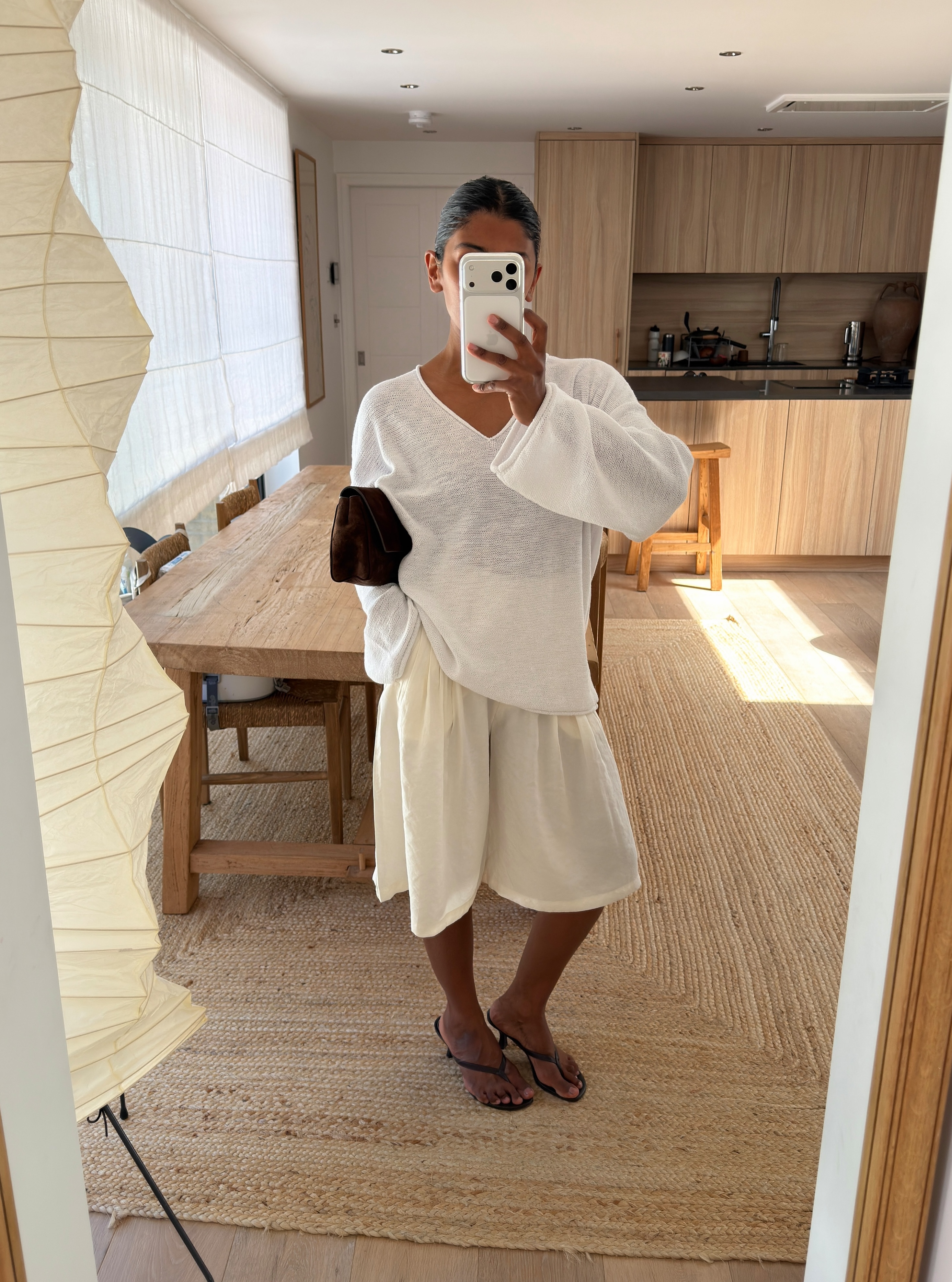 Monikh wearing a sheer jumper and long shorts
