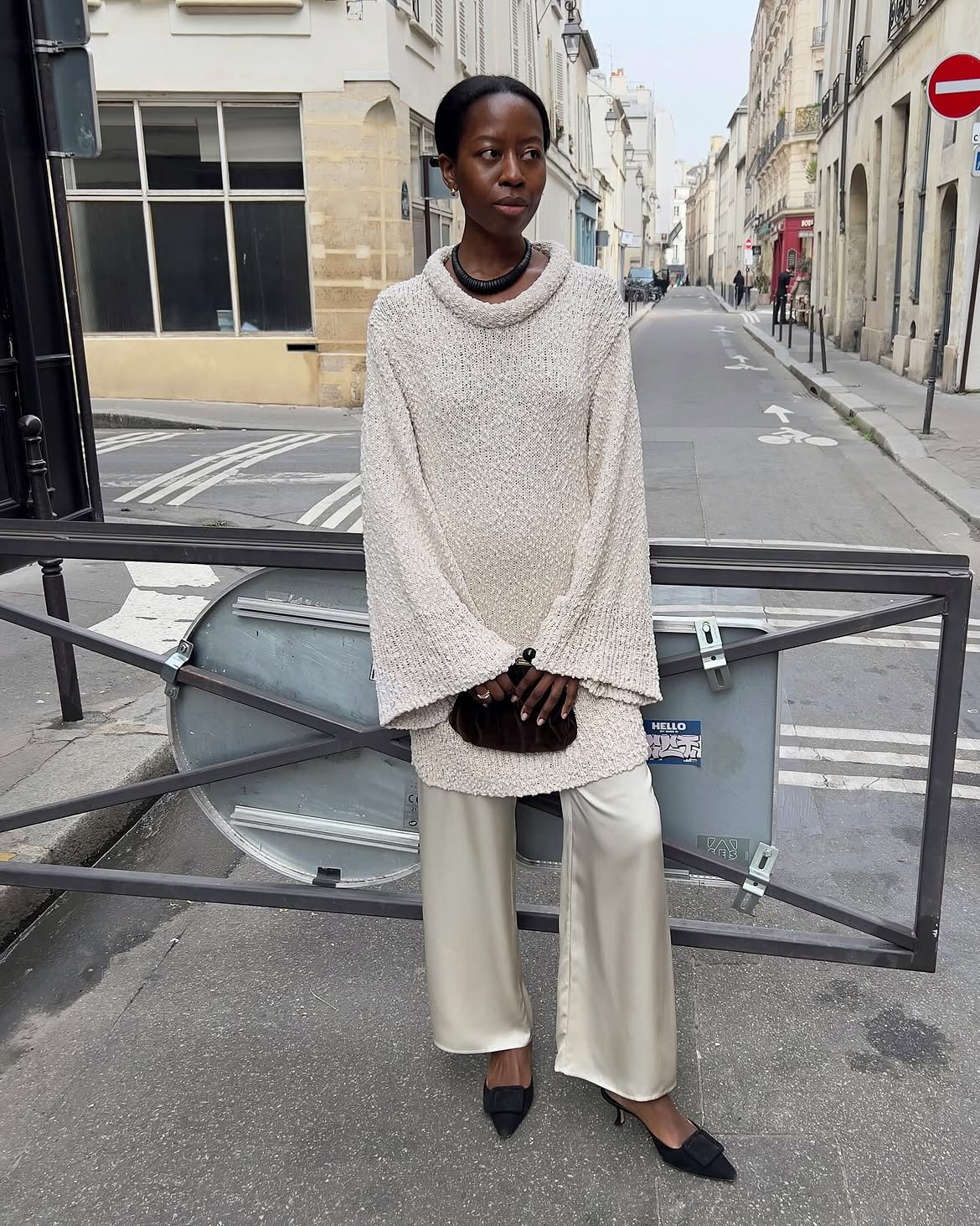 Sylvie Mus wearing an open knit sweater with silk pants in Paris