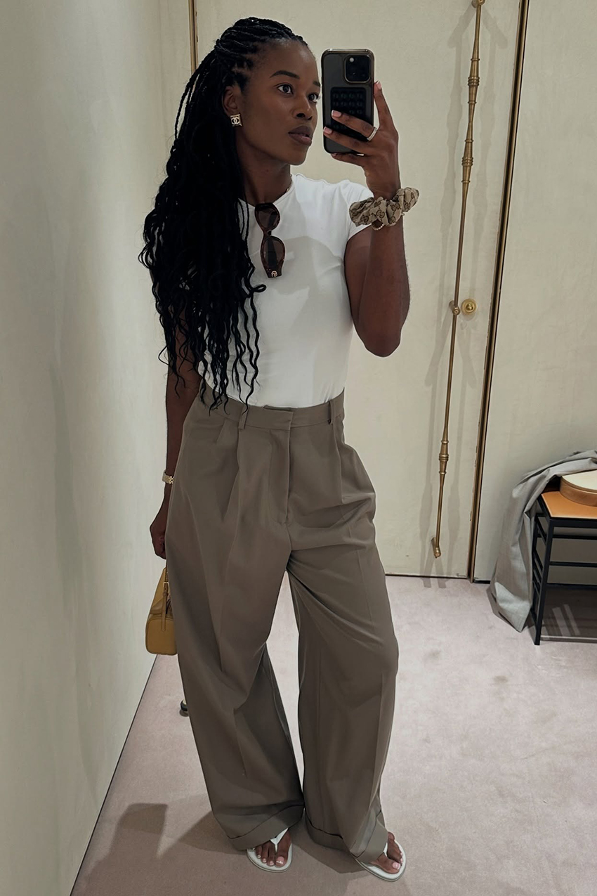 a woman wearing a white baby tee with khaki pants and white thong sandals