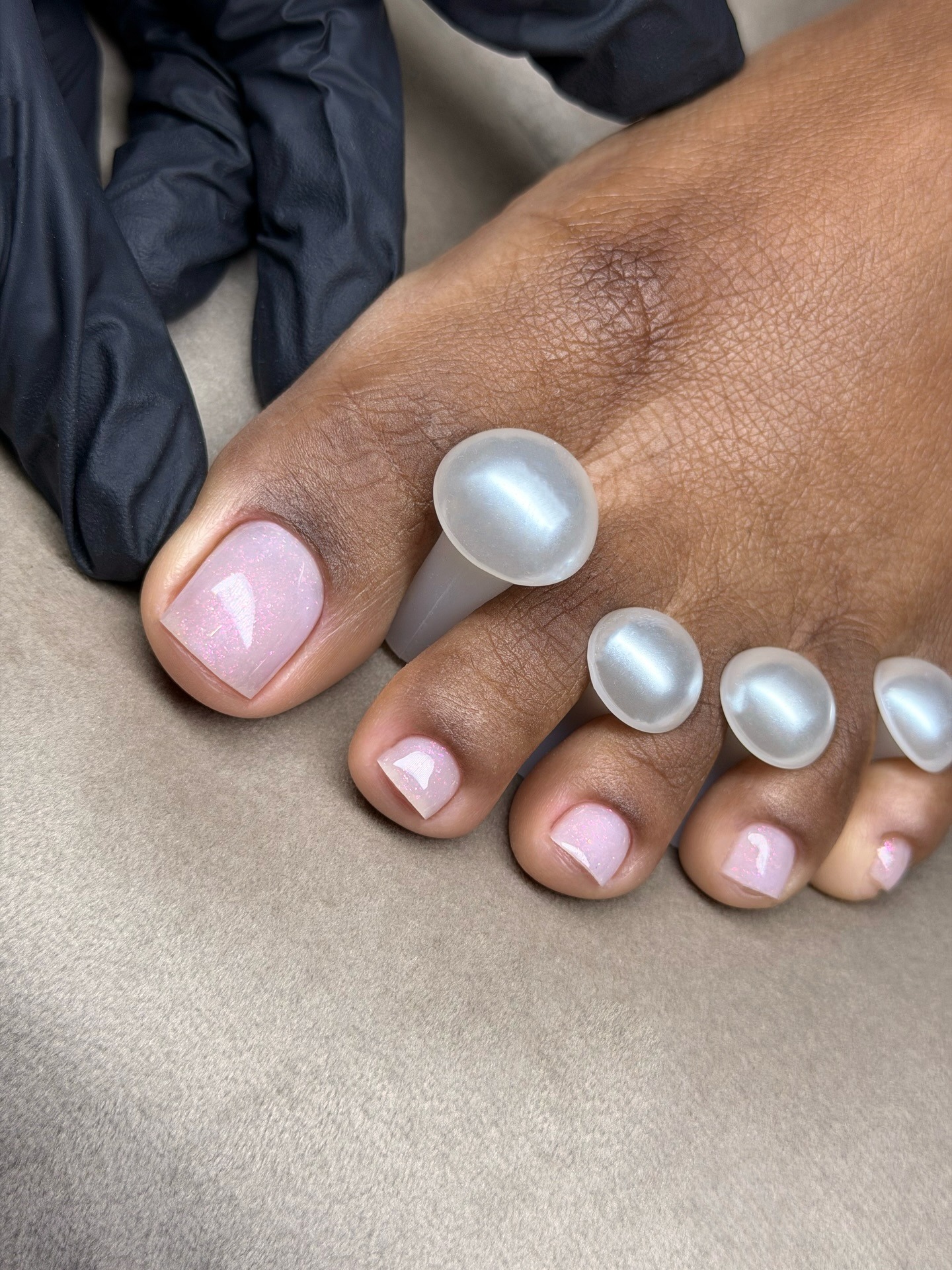 A sparkly, sheer pink chrome pedicure