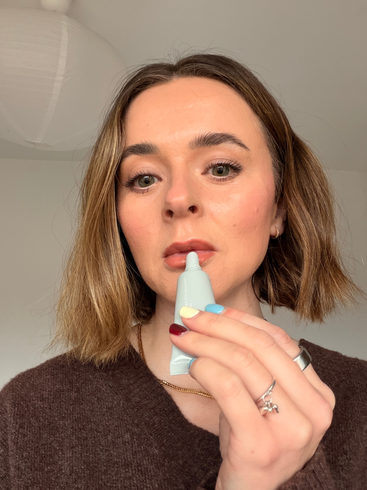 Grace applying the Rhode Lip Balm