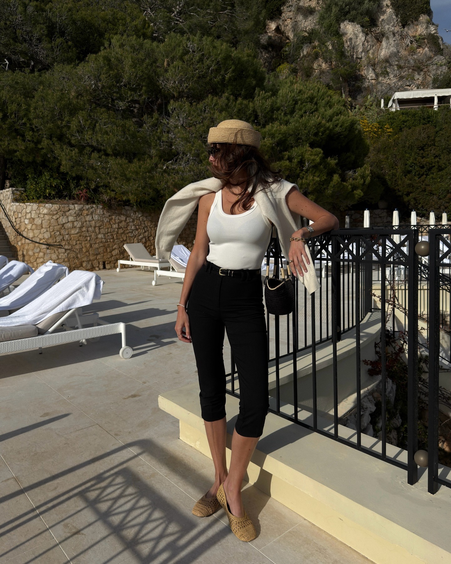 French influencer wearing a white tank and black capri pants with raffia ballet flats
