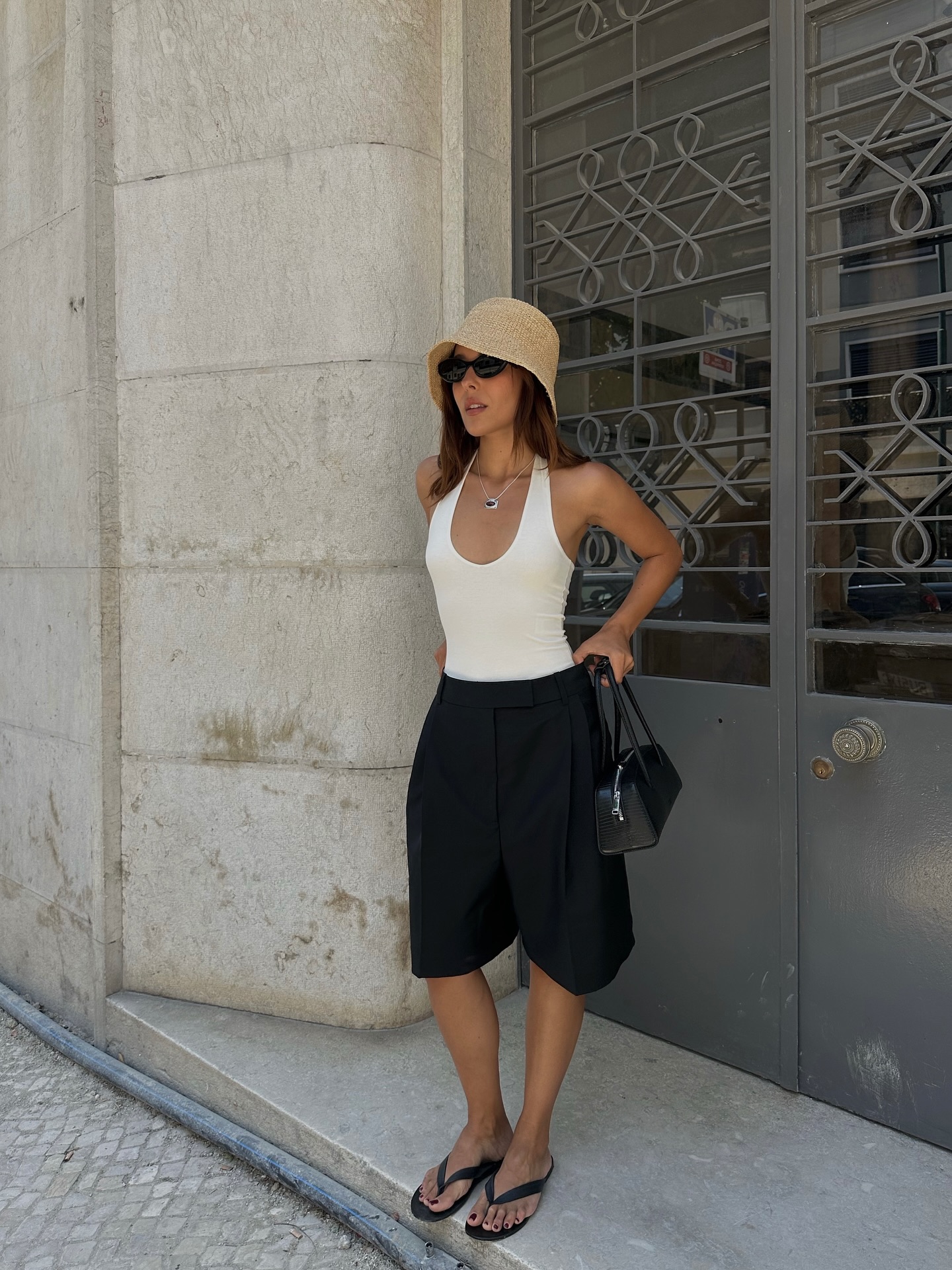 Debora in Bermuda shorts, woven hat and white vest