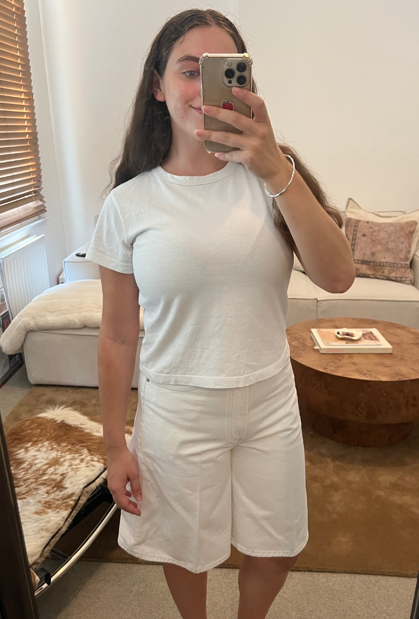 An image of Who What Wear fashion writer Ava Gilchrist wearing a pair of Agolde denim shorts, one of the best denim shorts for women in 2026.