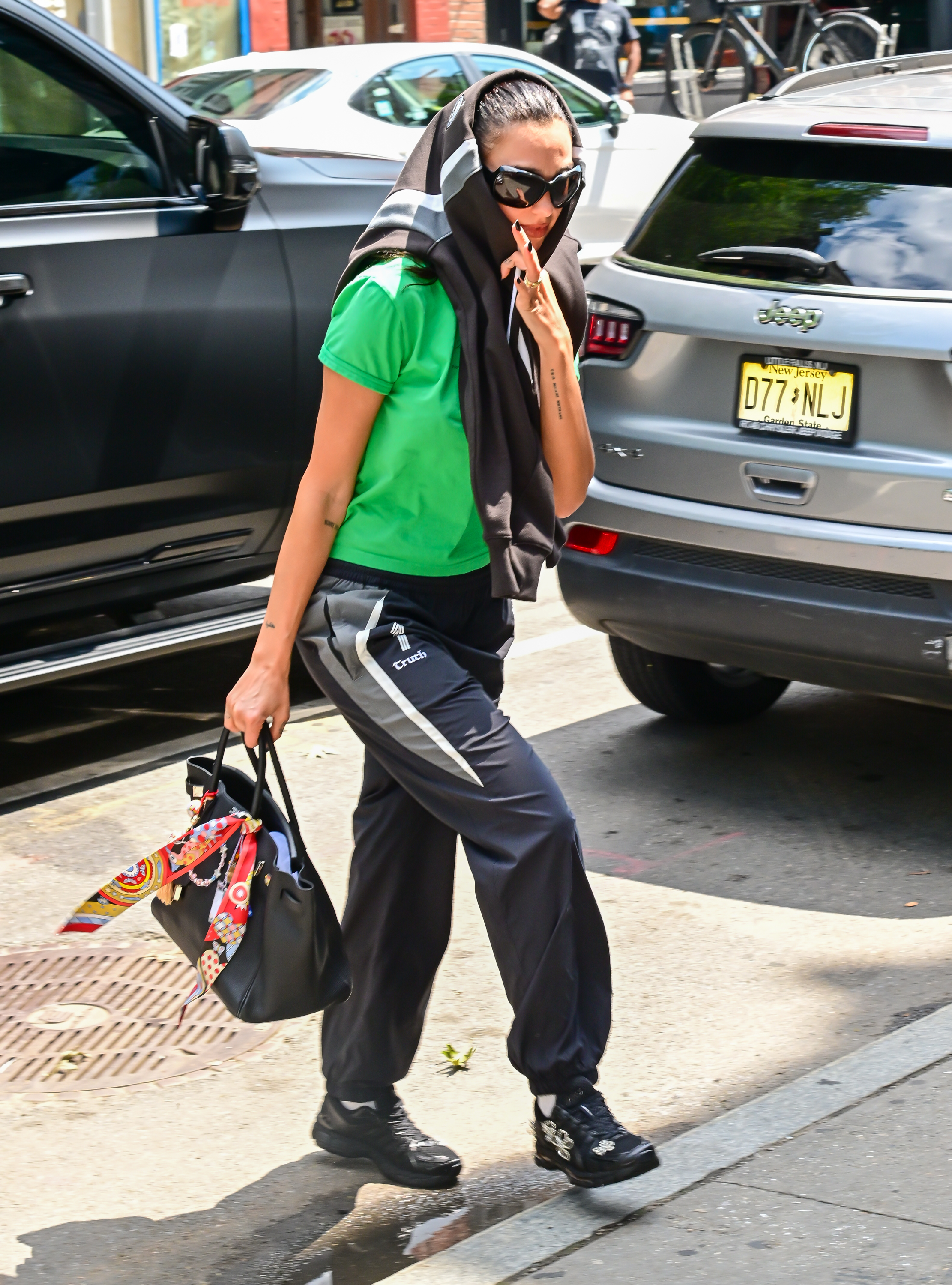 Dua Lipa wears track pants with Asics X Completed Works black trainers.