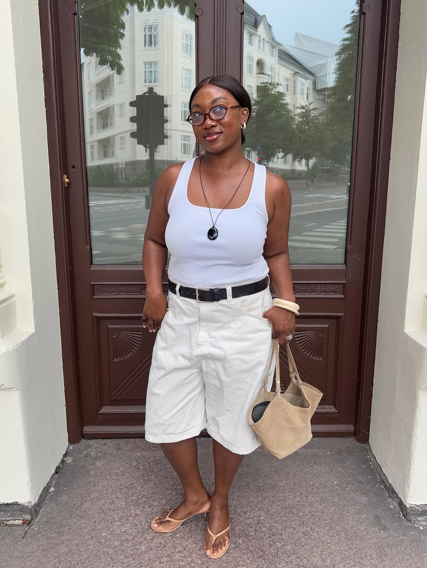 Nnenna in a white vest and Bermuda shorts