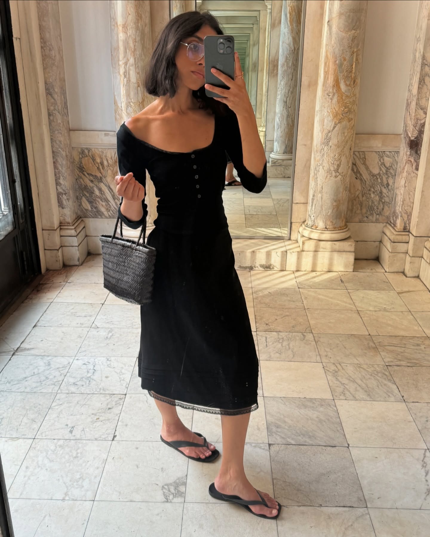 @shayinjune wearing a black T-shirt with a layered black knee-length skirt and flip-flops.