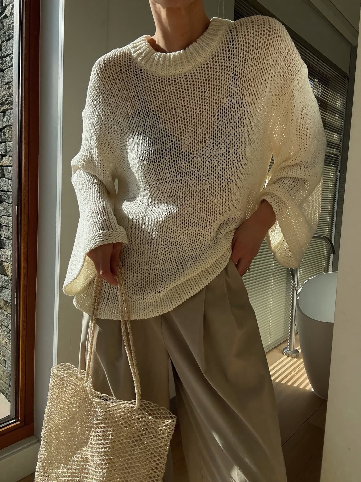 Anouk Yve wearing an open knit summer sweater with trousers