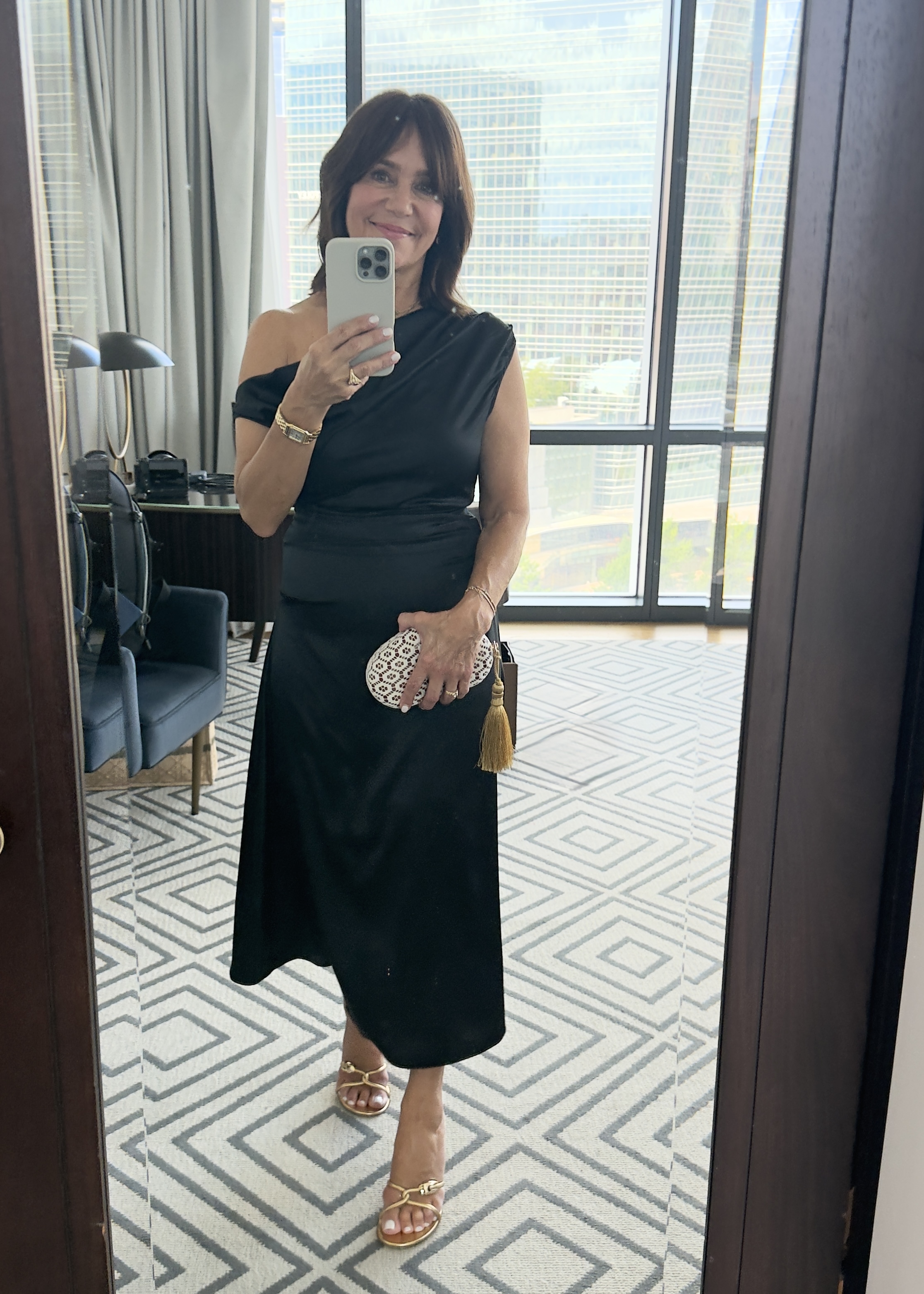 Susie Wright wearing a black midi dress and sandals.