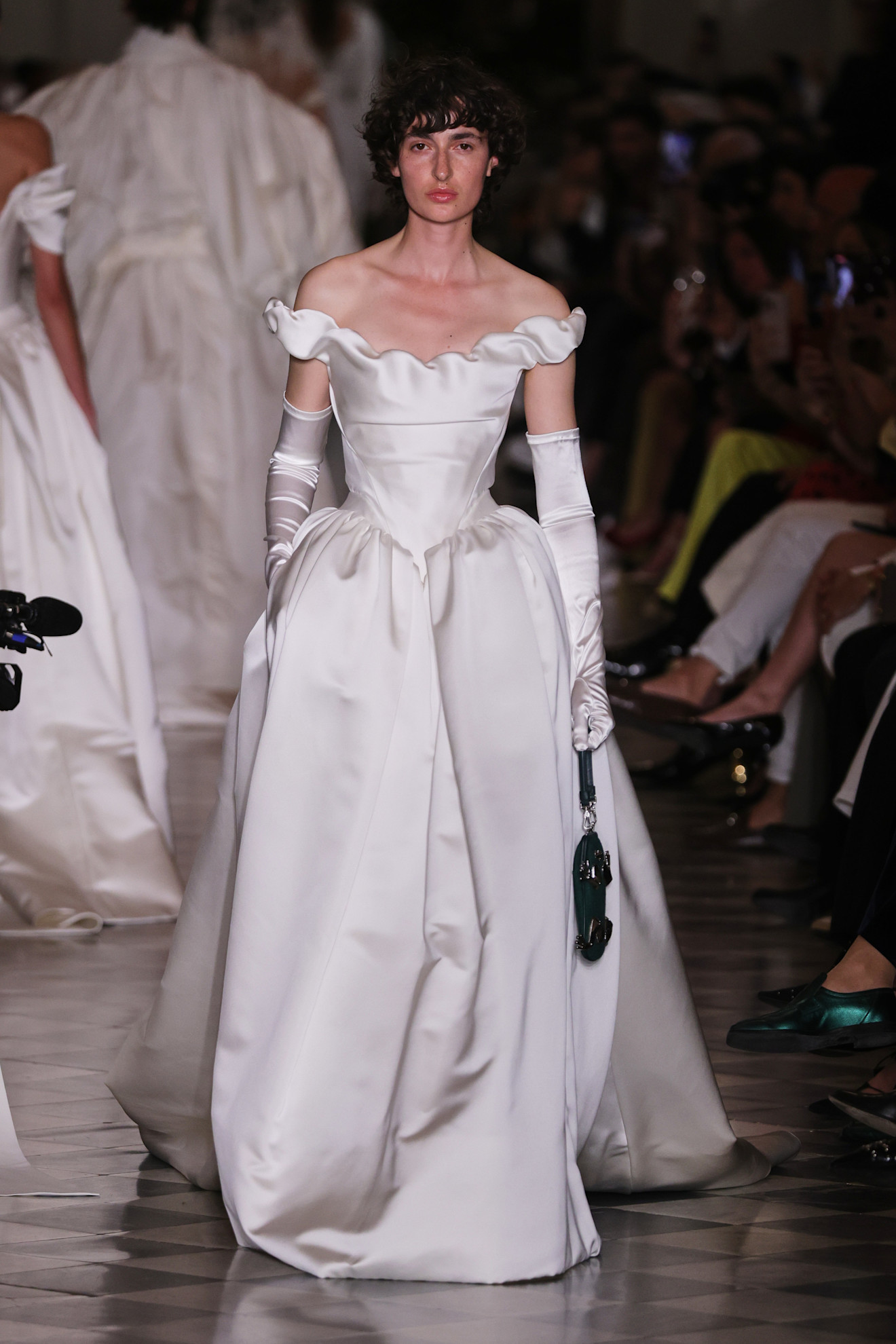 a woman wears a vivienne westwood bridal gown with white gloves.