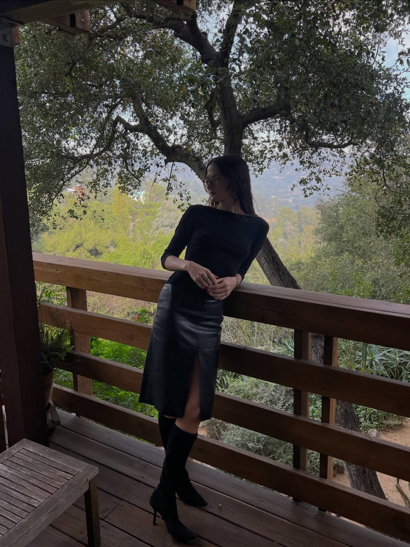 Eliza Huber wearing a boatneck t-shirt with a leather pencil skirt and knee-high boots.
