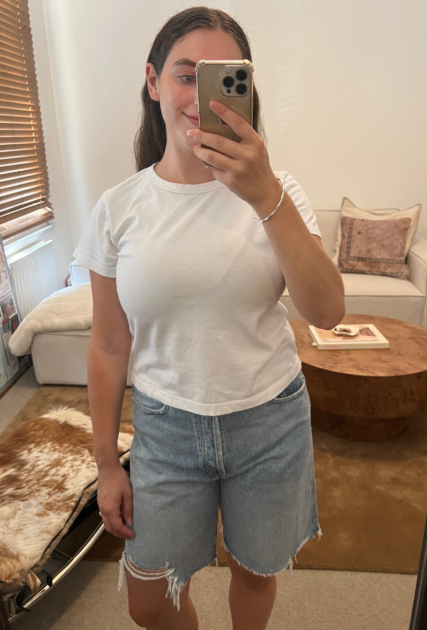 An image of Who What Wear fashion writer Ava Gilchrist wearing a pair of Agolde denim shorts, one of the best denim shorts for women in 2026.