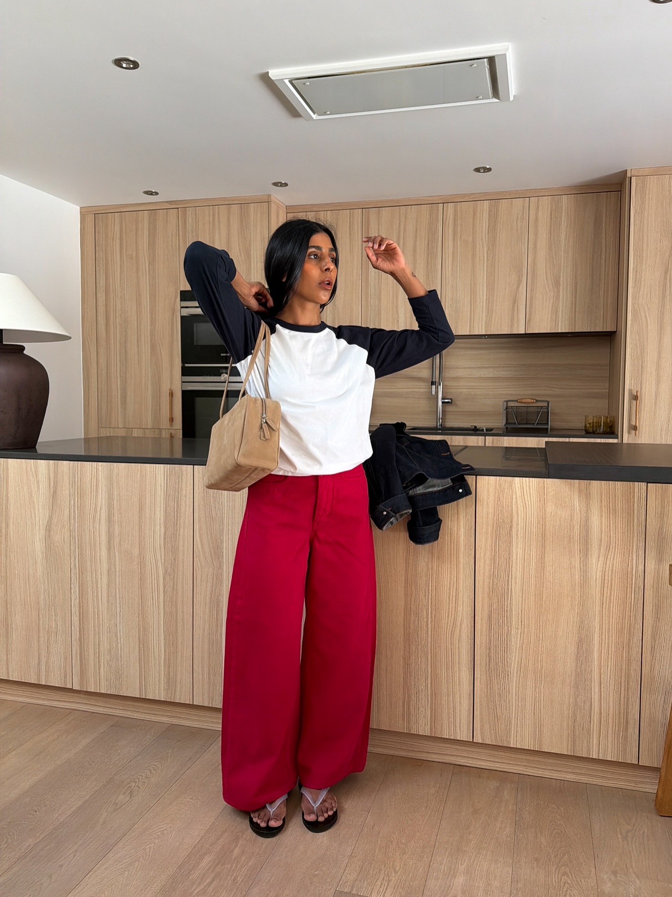 An image of @monikh wearing red jeans with clear shoes.