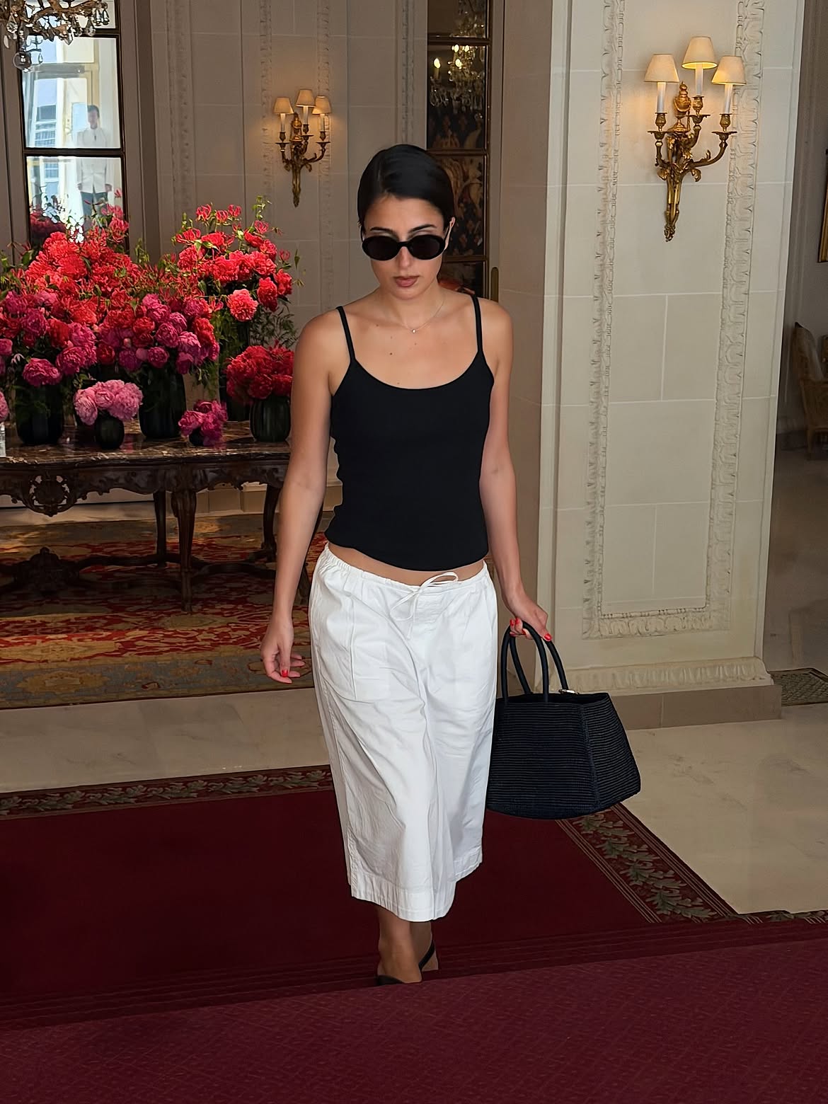 Tamara Mory in a black tank and white culottes