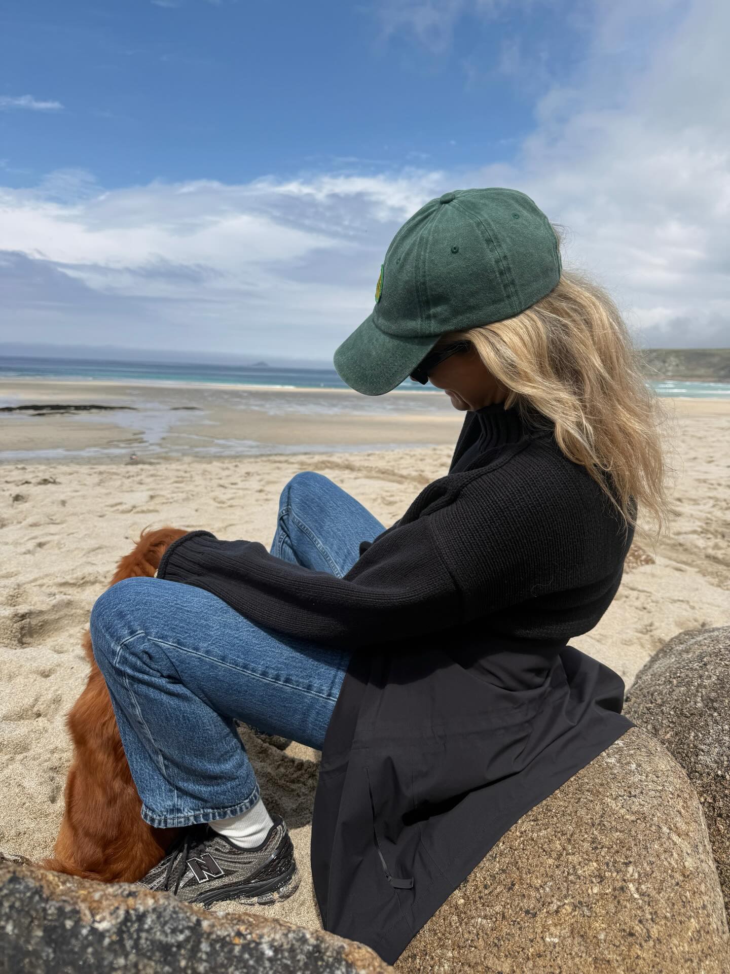 Influencer Lucy Williams wearing New Balance trainers, jeans, black coat and baseball cap.