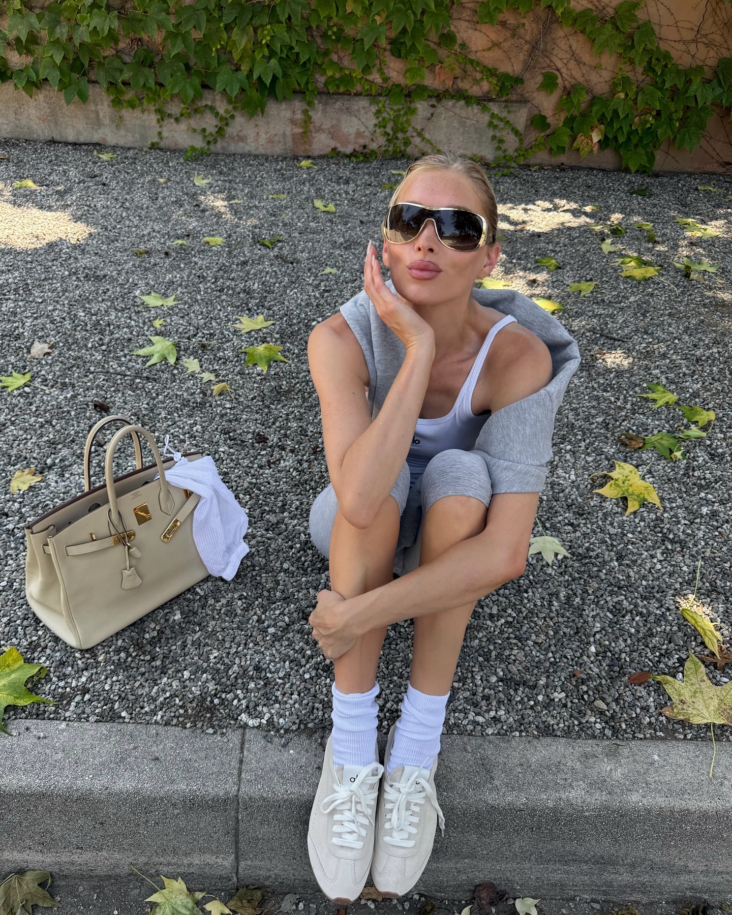 Model @hoskelsa wears shield sunglasses with a grey leggings two-piece.