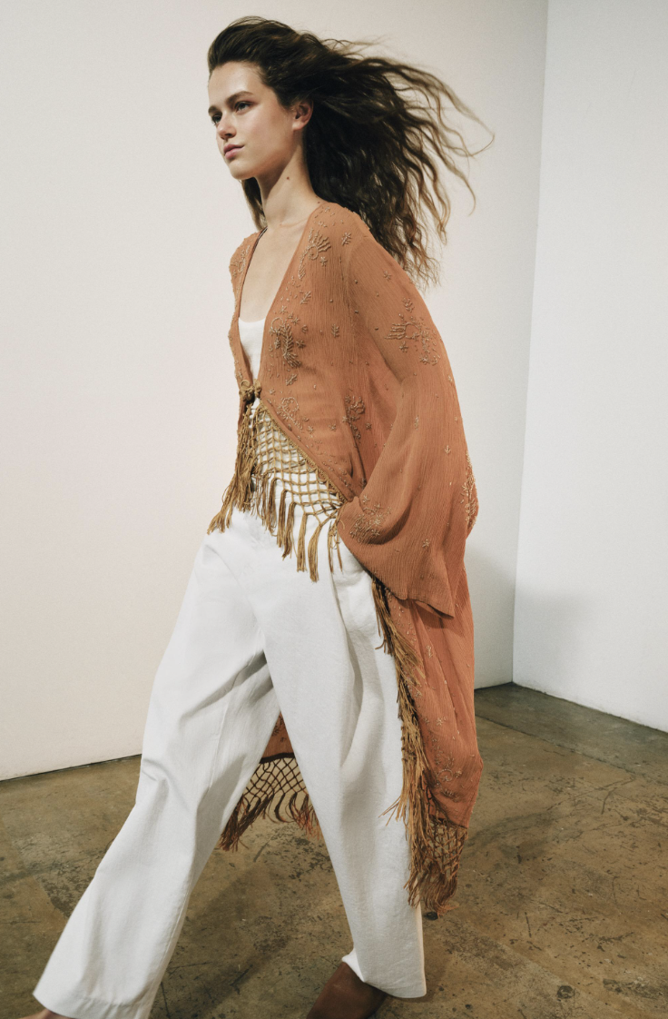 Image of Zara's early autumn fashion trends 2026. The model wears a burnt orange Kaftan over white jeans.