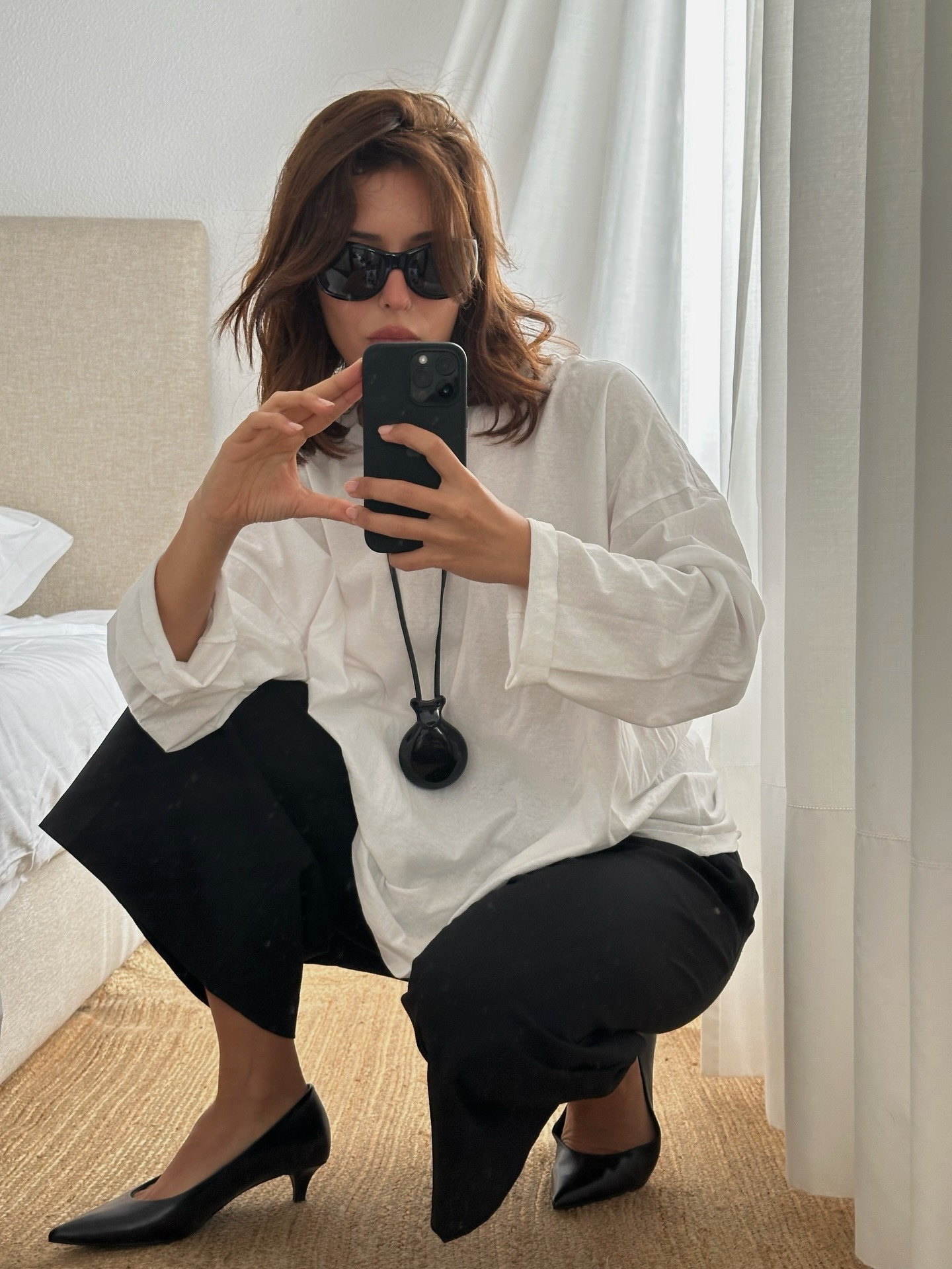 @deborabrosa wearing a white long sleeve T-shirt and black pants