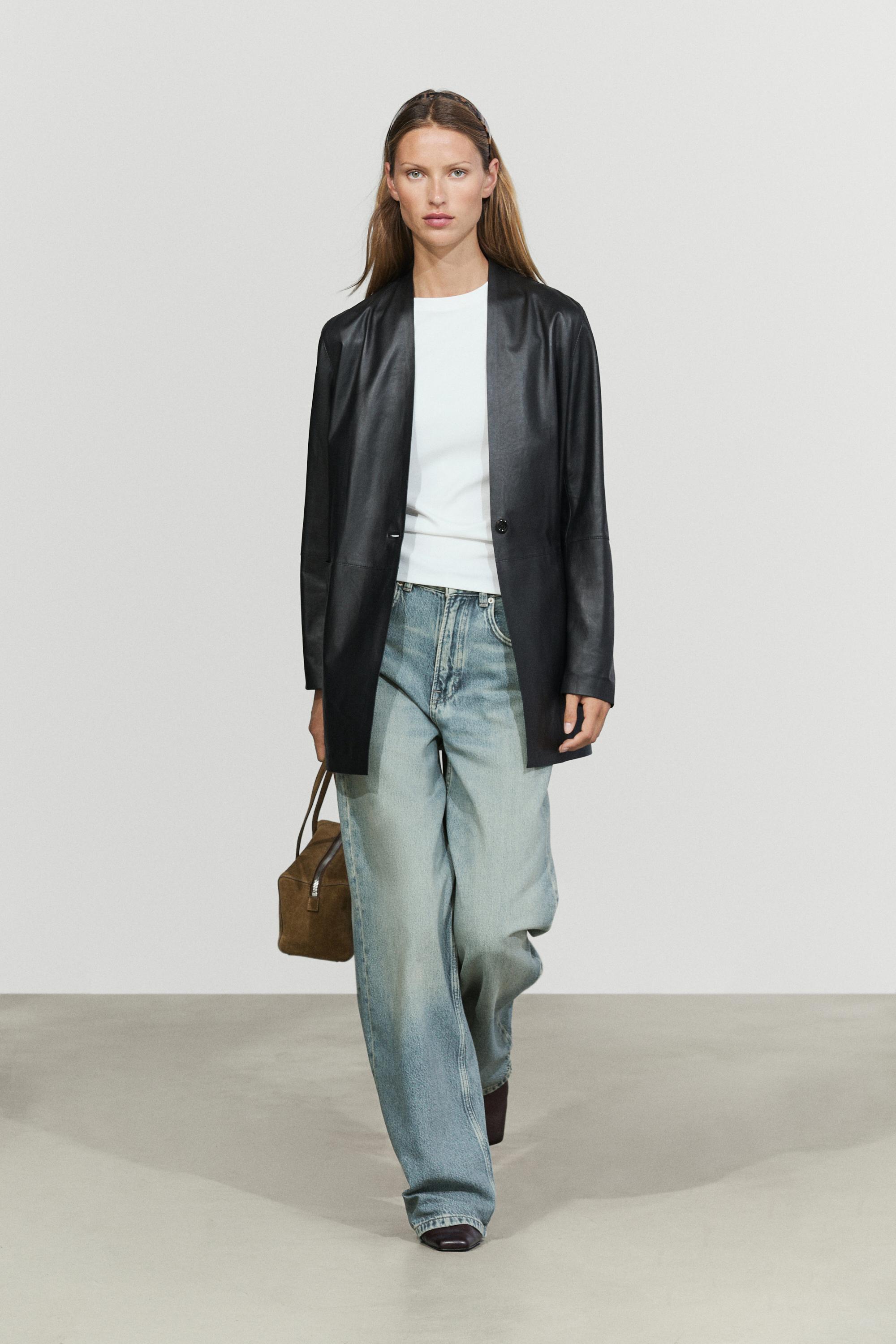 An image of a Massimo Dutti model wearing a white T-shirt, blue jeans and a black leather jacket