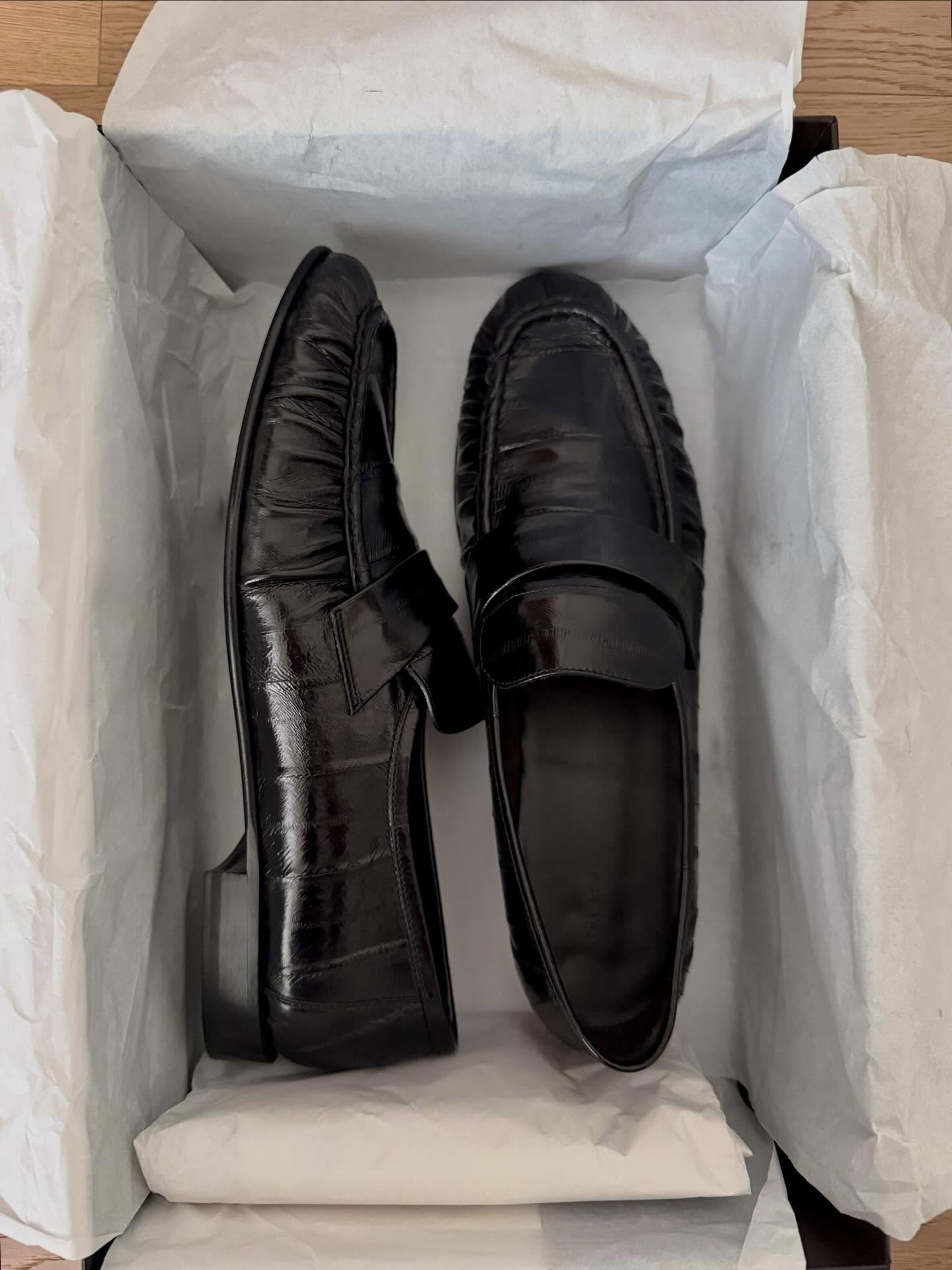 A pair of eel-skin The Row loafers.