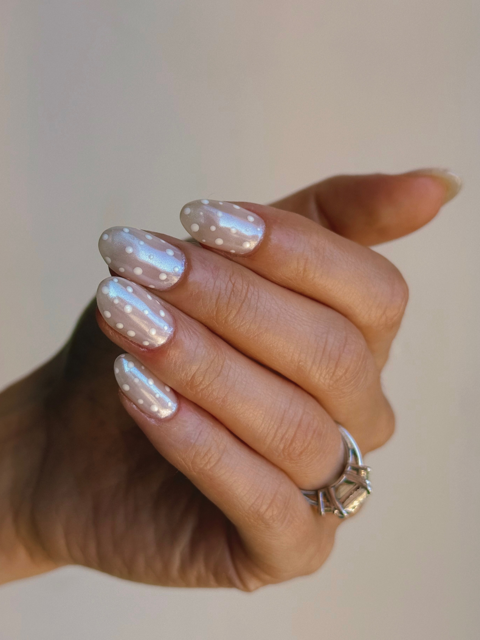 Polka dot nails on a chrome base.