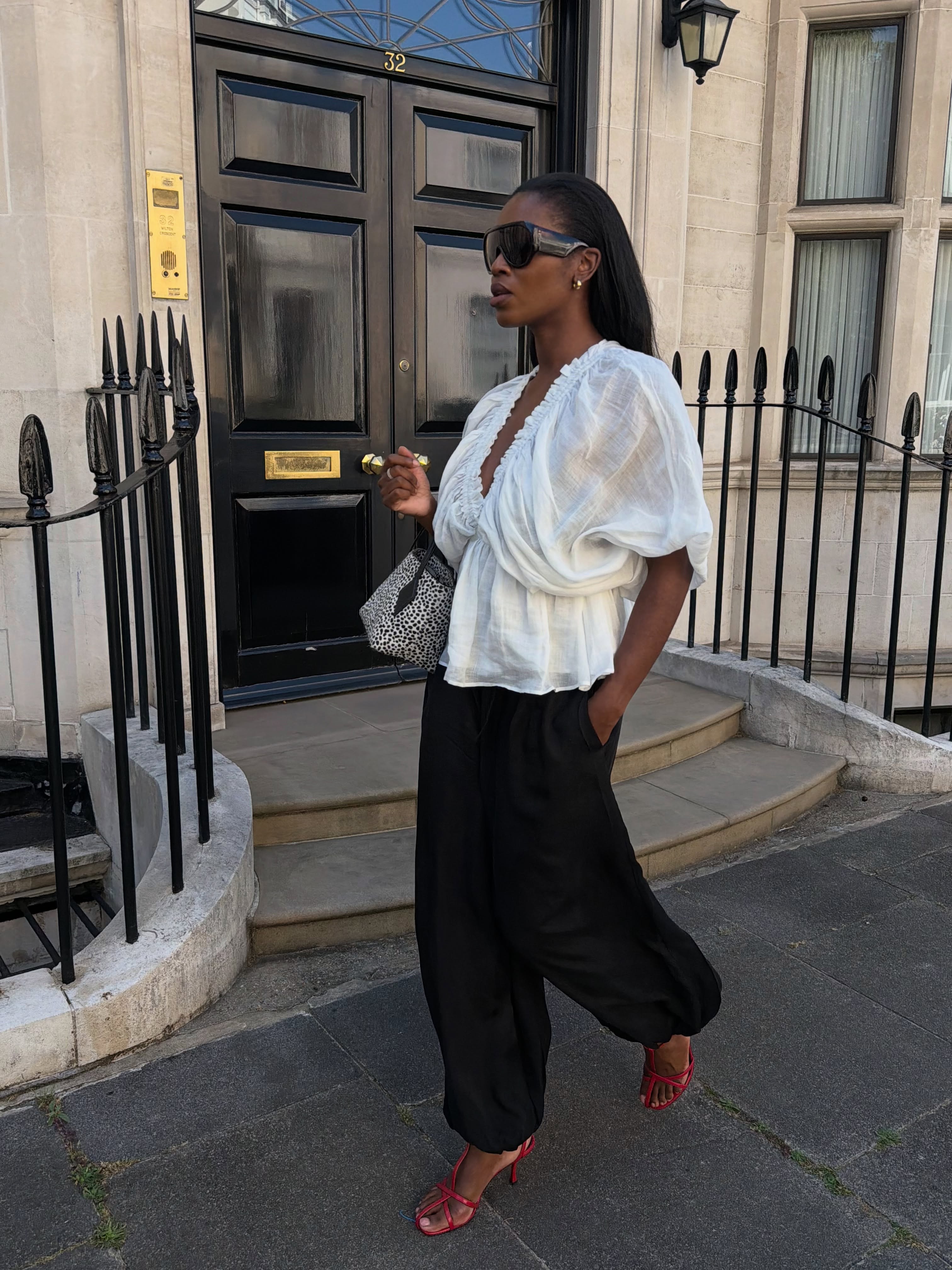 An image of @nlmarilyn wearing a waisted top with a pair of balloon trousers and red T-bar sandals.