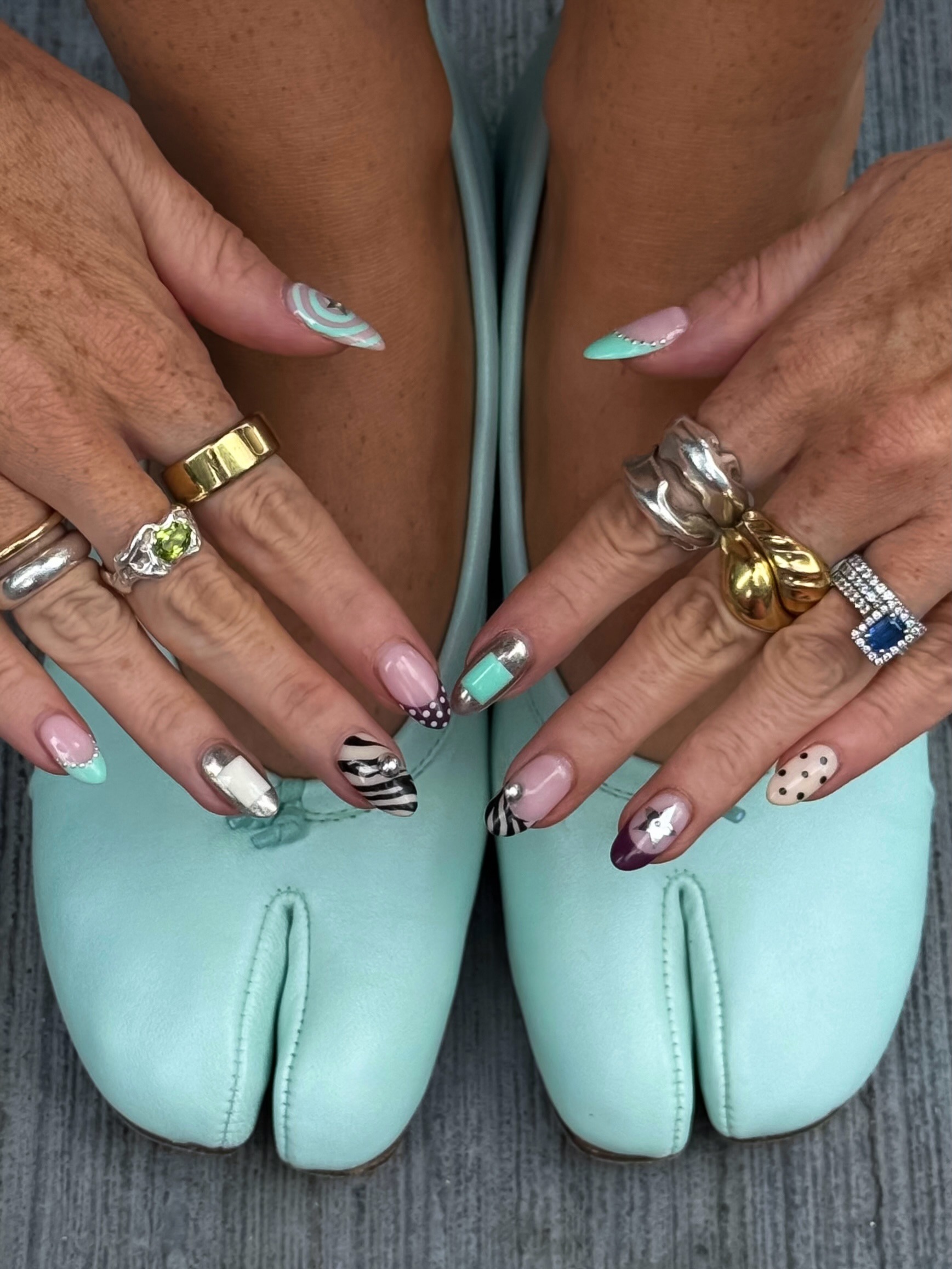 Creator @rebeccaferrazwyatt with blue, black and brown nail art, including spots and zebra print