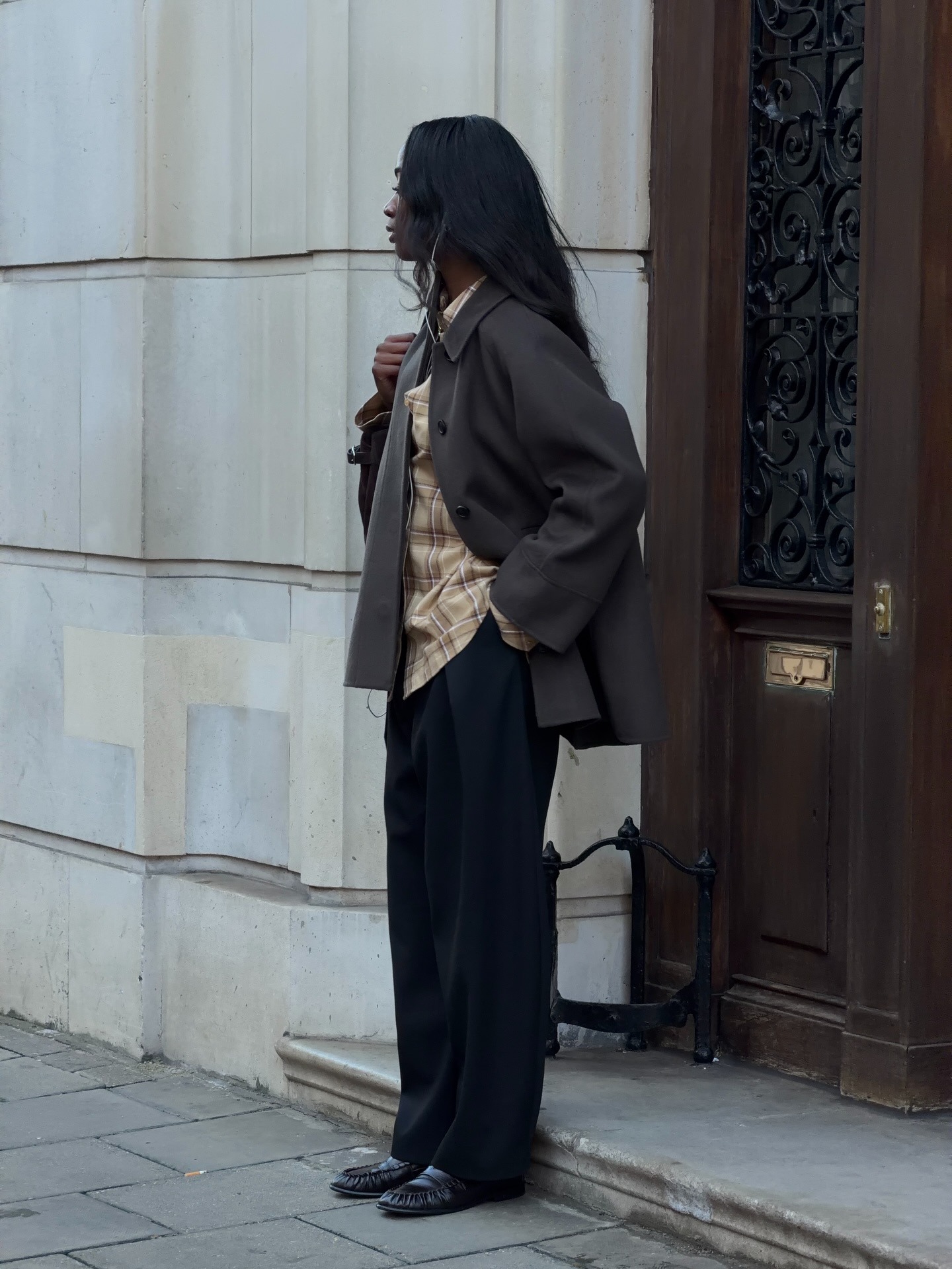 @_livmadeline wearing black trousers, a coat, and loafers