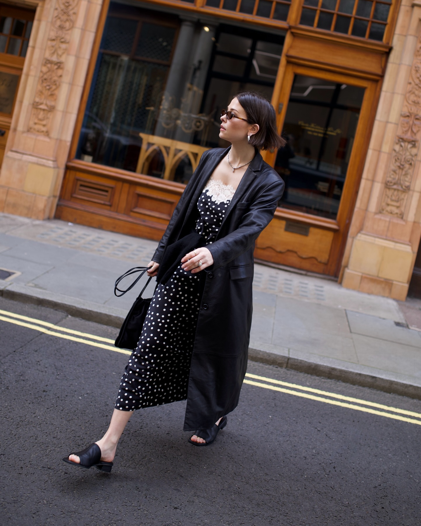 Influencer Alice Satterthwaite wearing a polkadot dress, leather trend and leather mules.