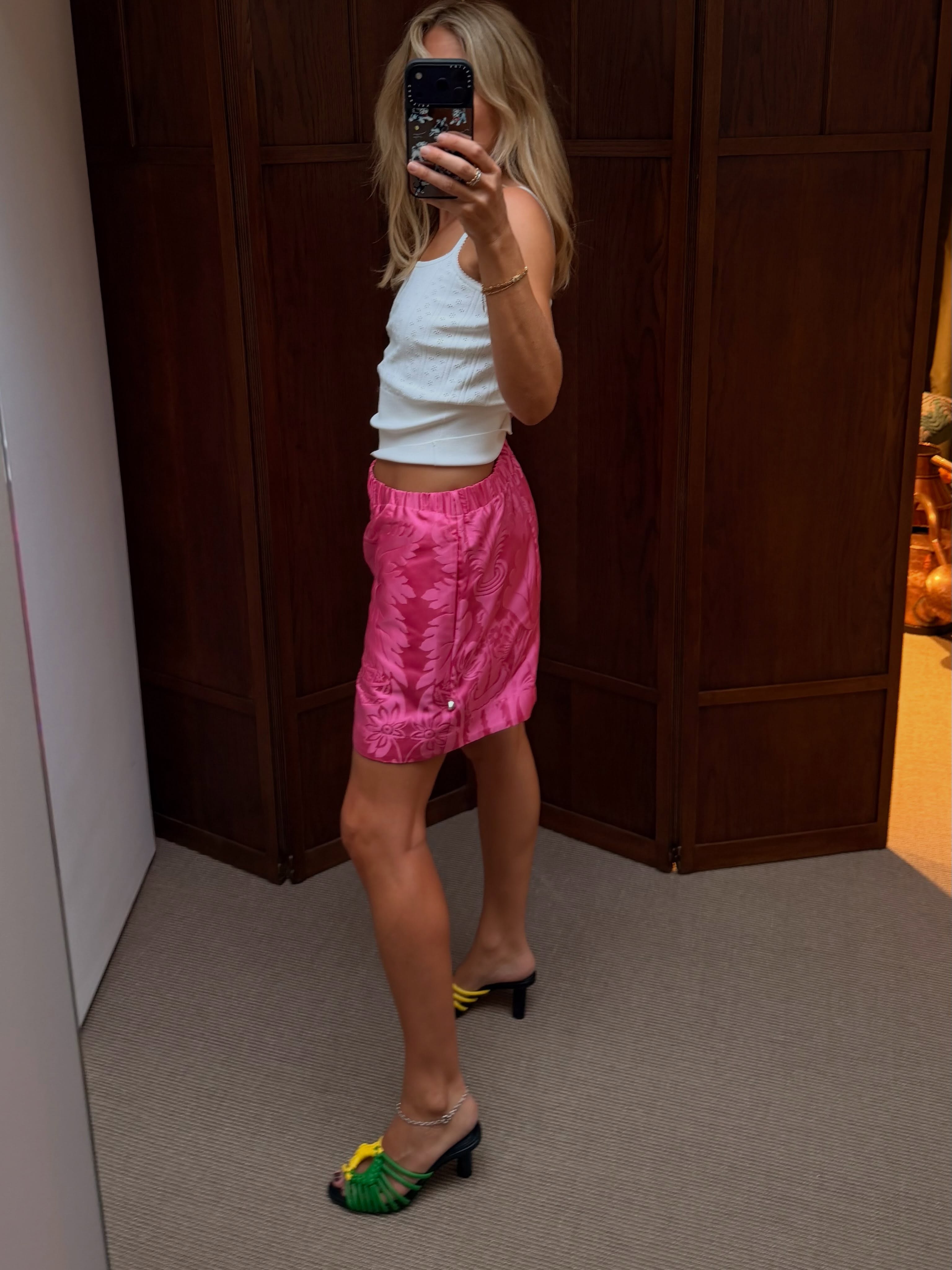 An image of @lucywilliams02 wearing long jacquard shorts with a white pointelle tank top and heels.