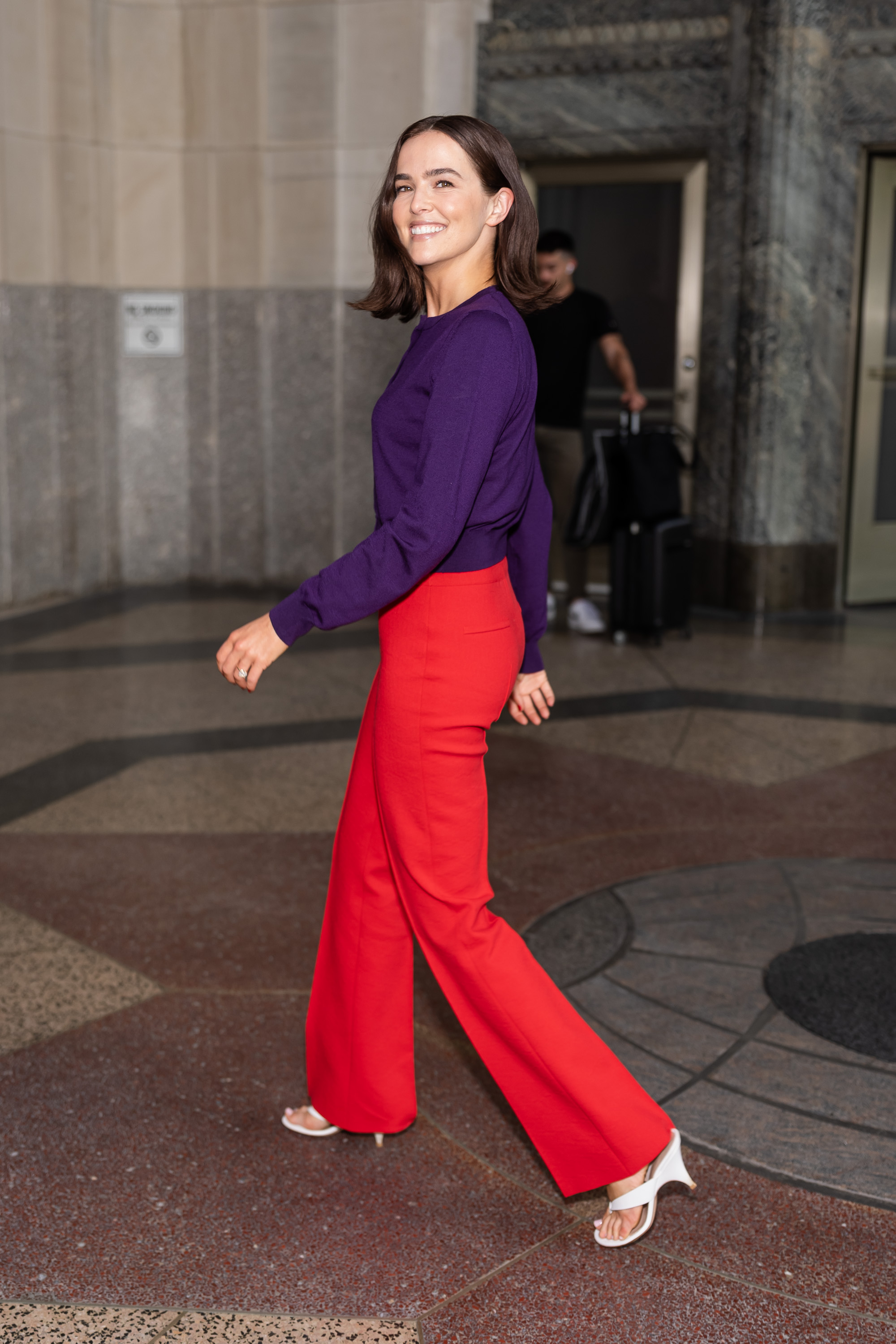 An image of Zoey Deutch wearing the red and purple colour trend whilst out in New York.