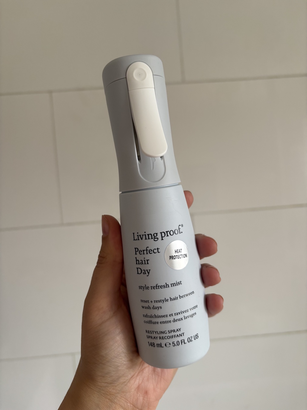 Mica Ricketts holding Living Proof Style Refresh Mist