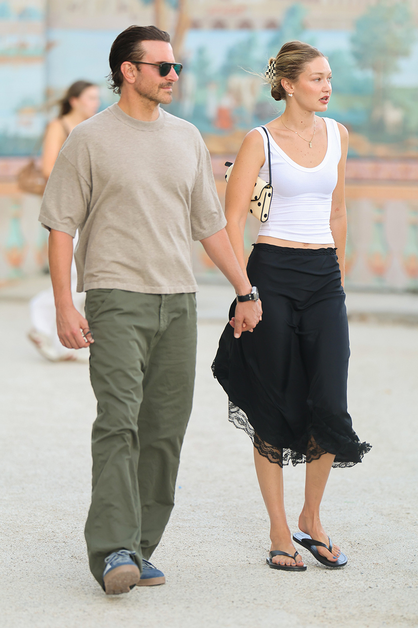 Gigi Hadid walking with Bradley Cooper in Paris. Gigi wore a white tank top with a black lace-trimmed midi skirt and black leather flip-flops. She carried a polka-dot Valentino Garavani DeVain bag