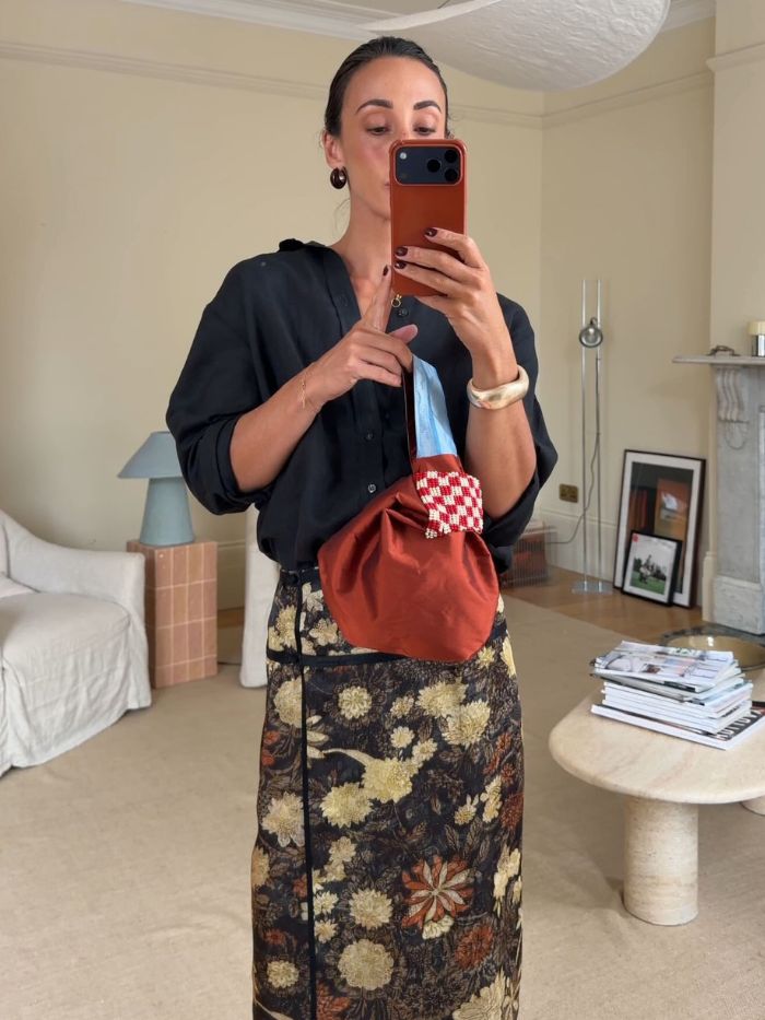Woman wears black shirt, floral skirt
