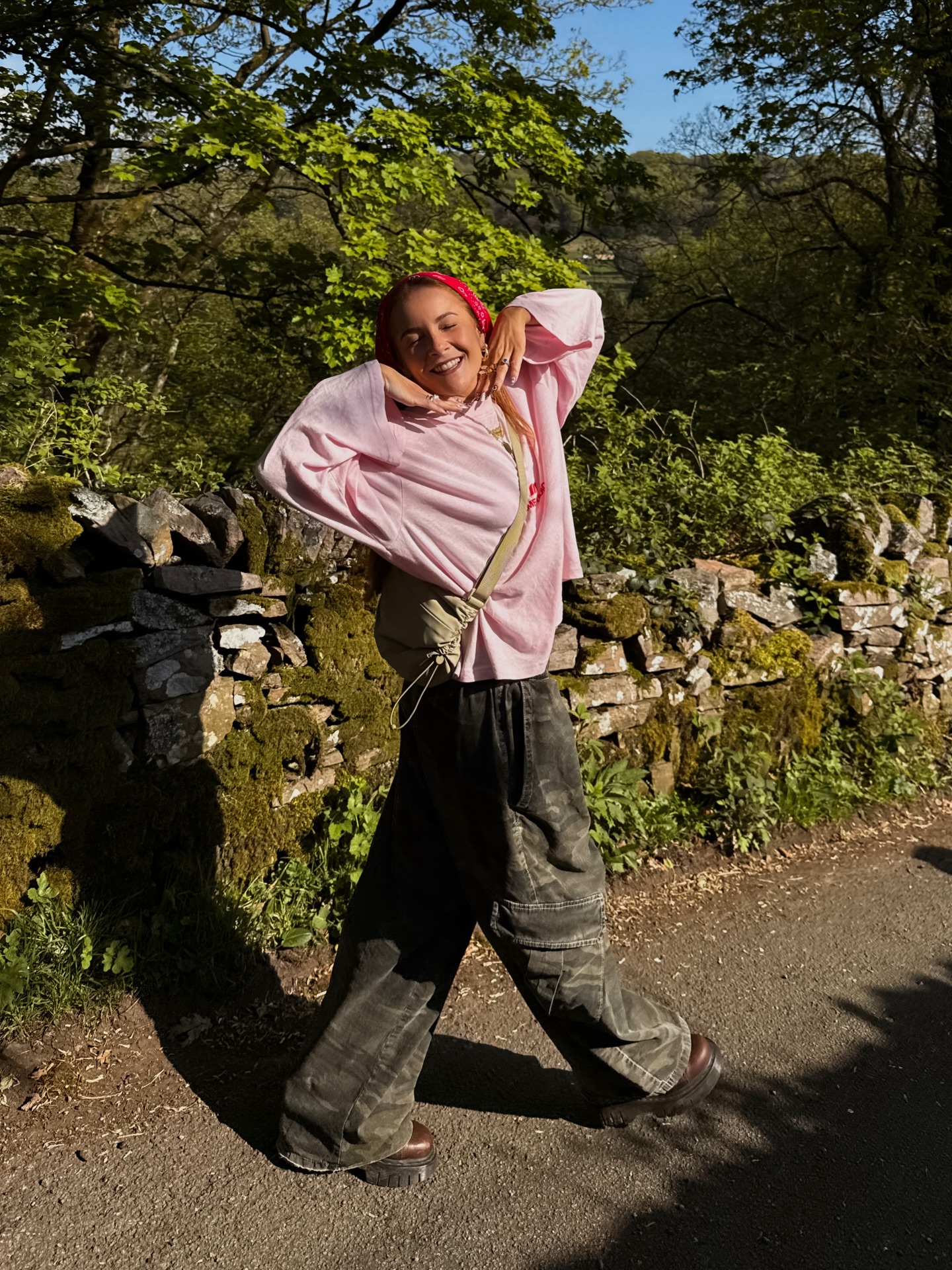 Influencer Rebecca Ferraz Wyatt wearing a pink long sleeve t-shirt, camo jeans and flatform boots.