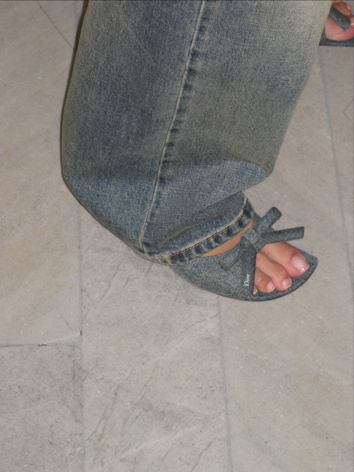 Alexa Chung wears denim heels with jeans and a white tank top.