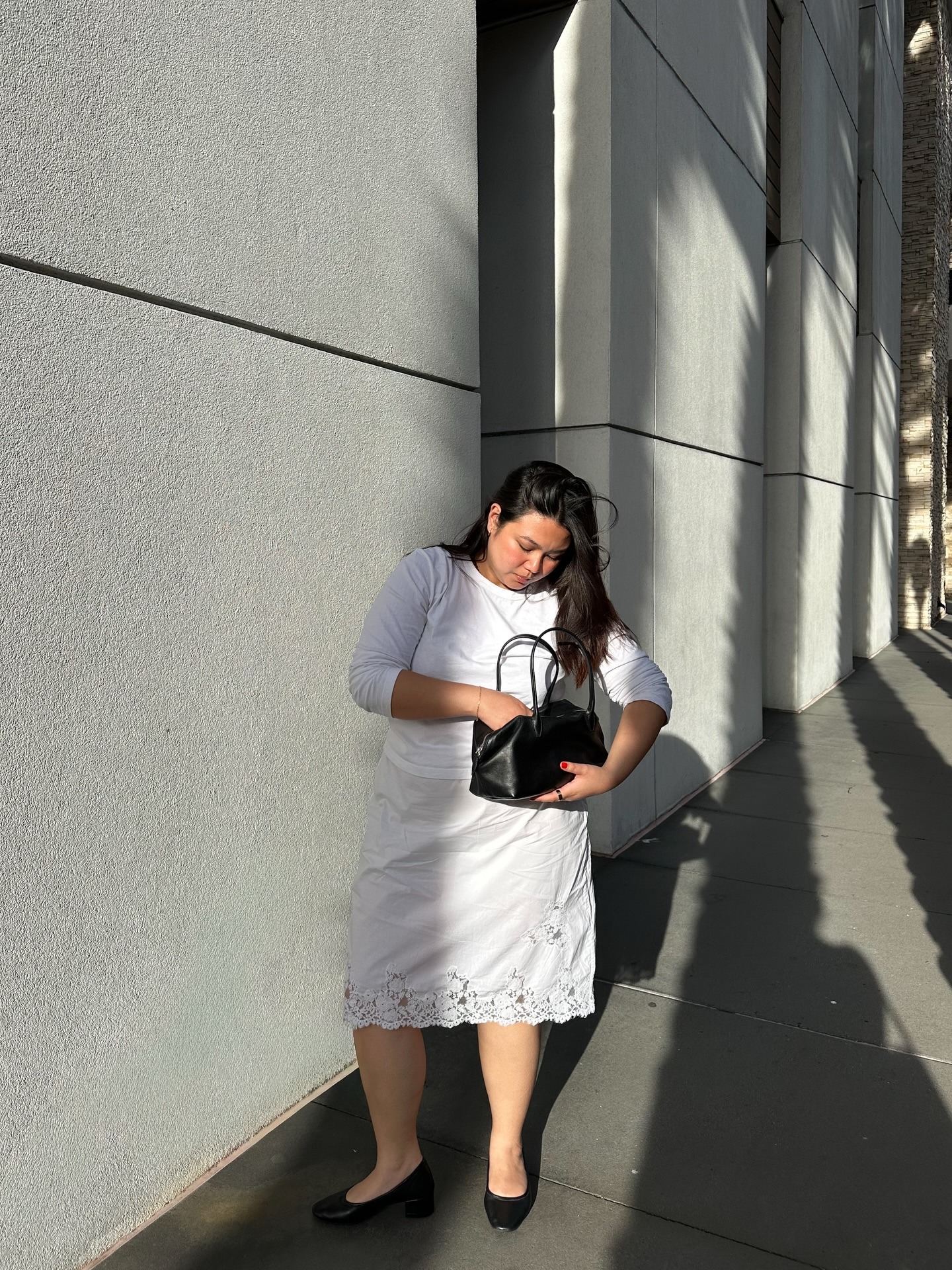 @marina_torres wearing a lace-trim skirt, crewneck, and black flats.