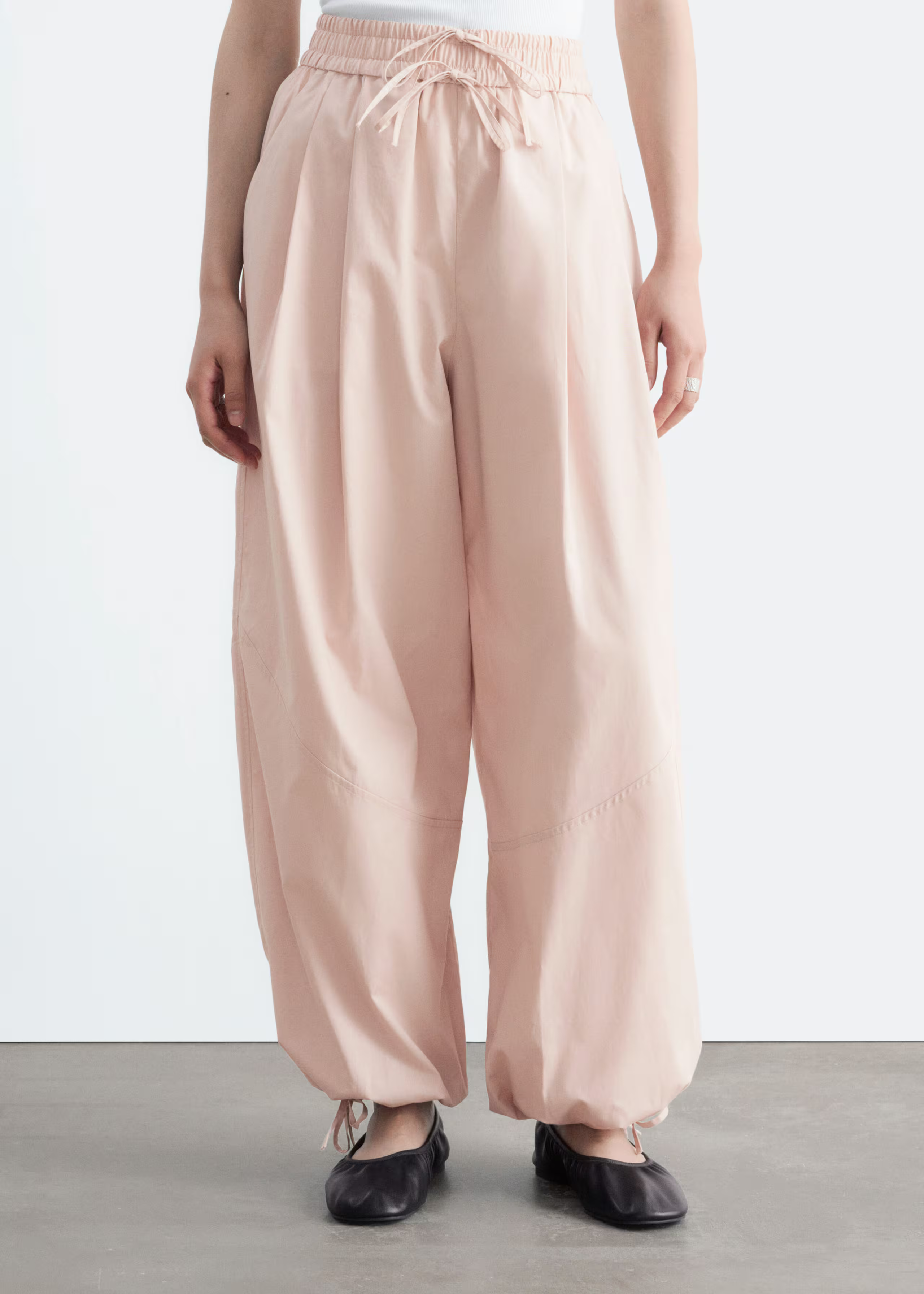 A model wears a pair of pink & Other Stories balloon trousers.