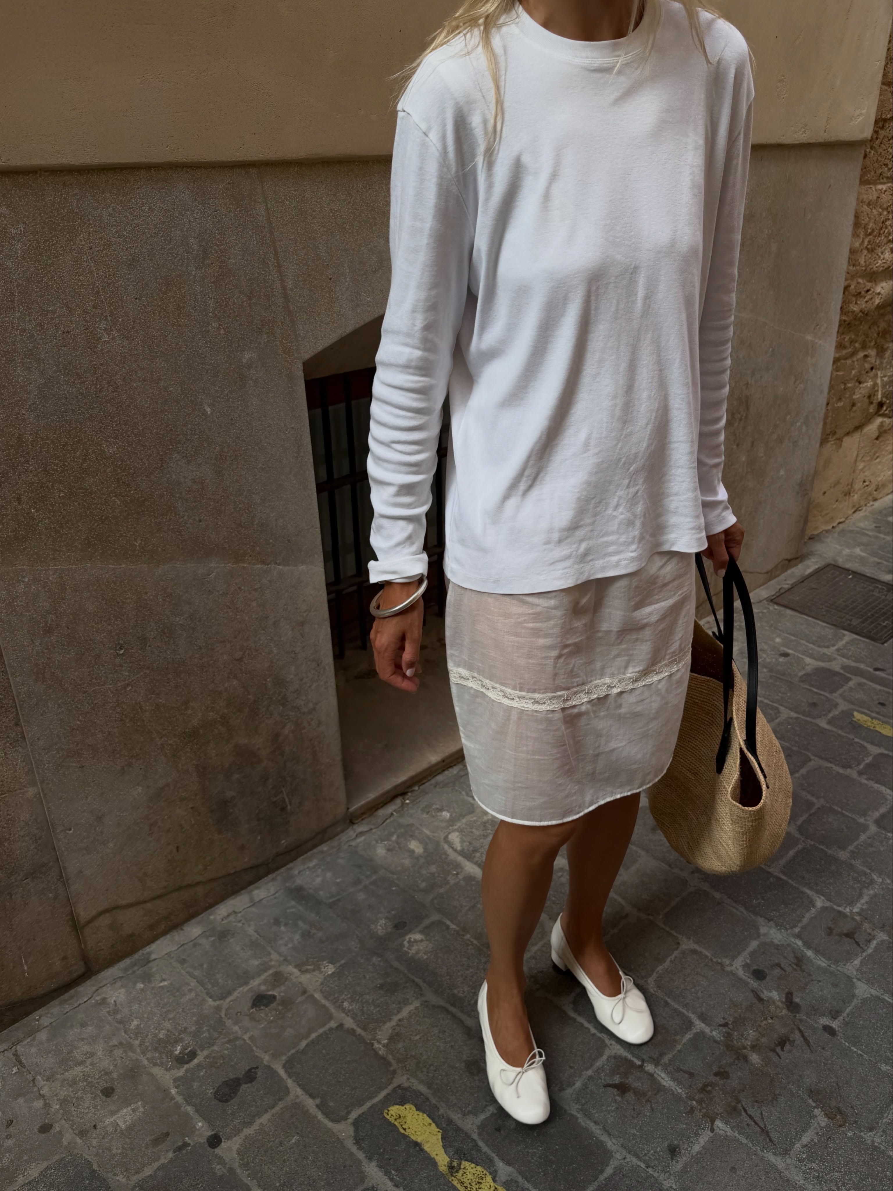 Woman in a white long sleeve top and sheer skirt