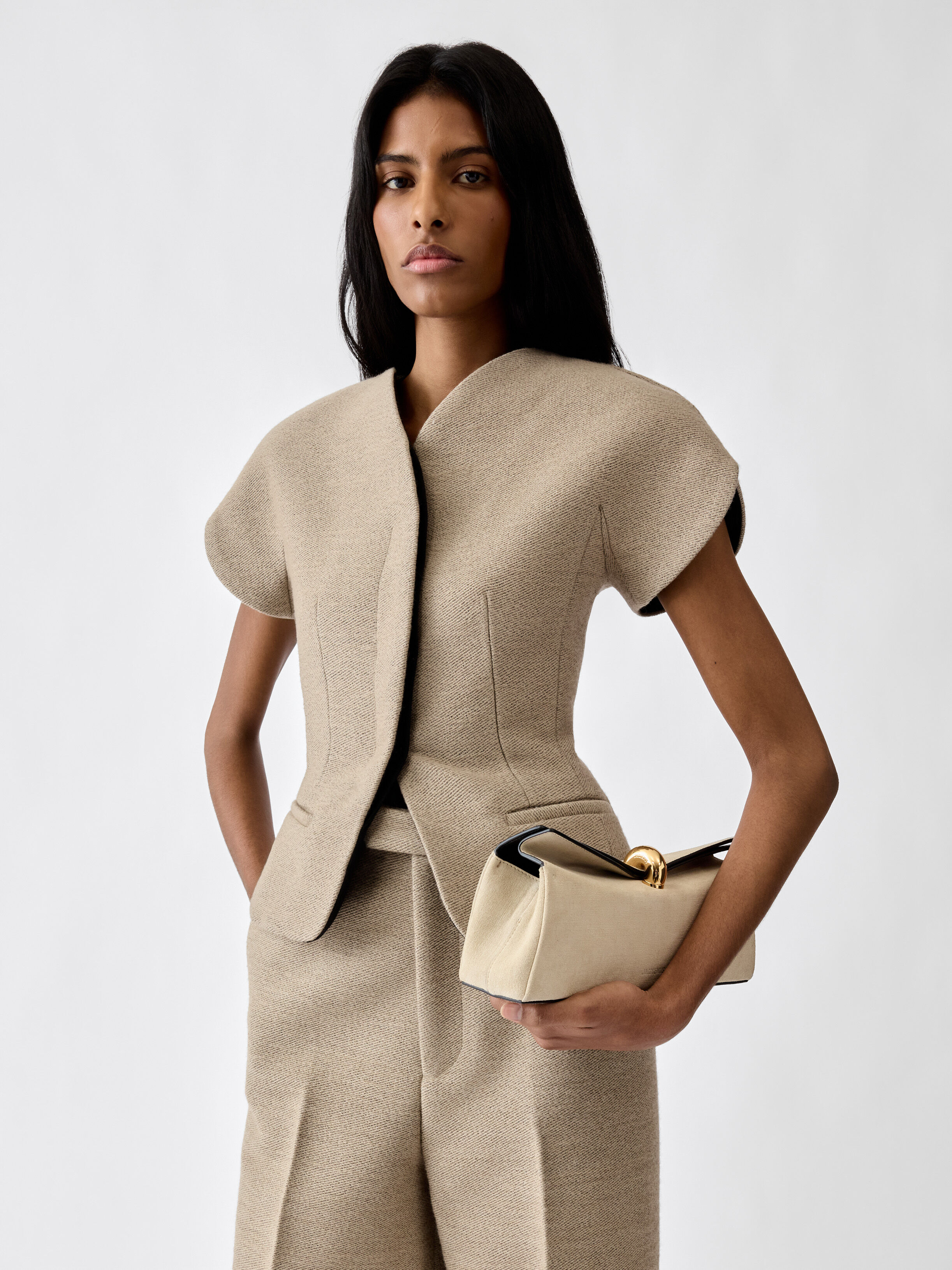 An image of a model wearing a short-sleeved beige blazer