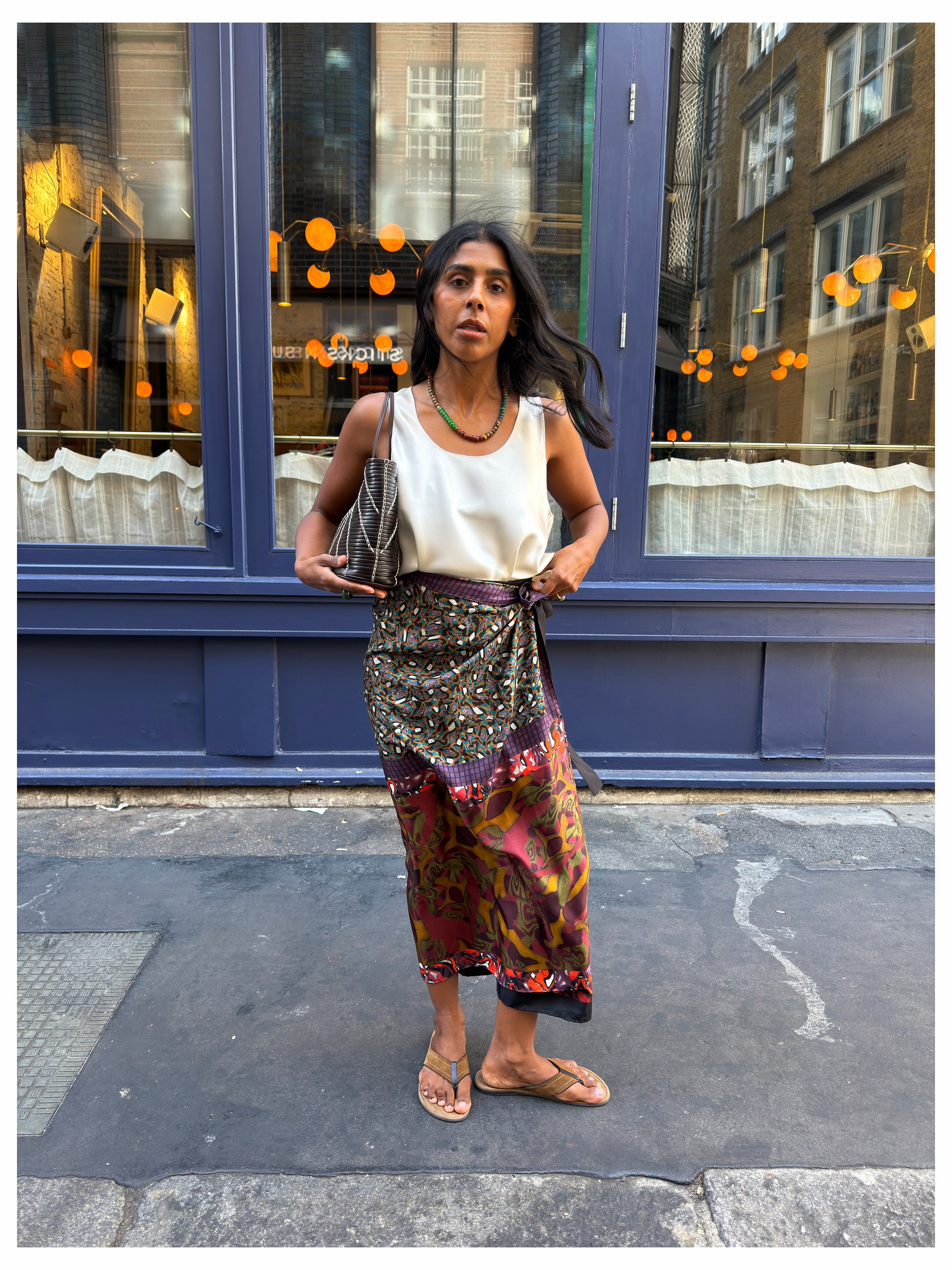 Woman in print skirt and white silk top