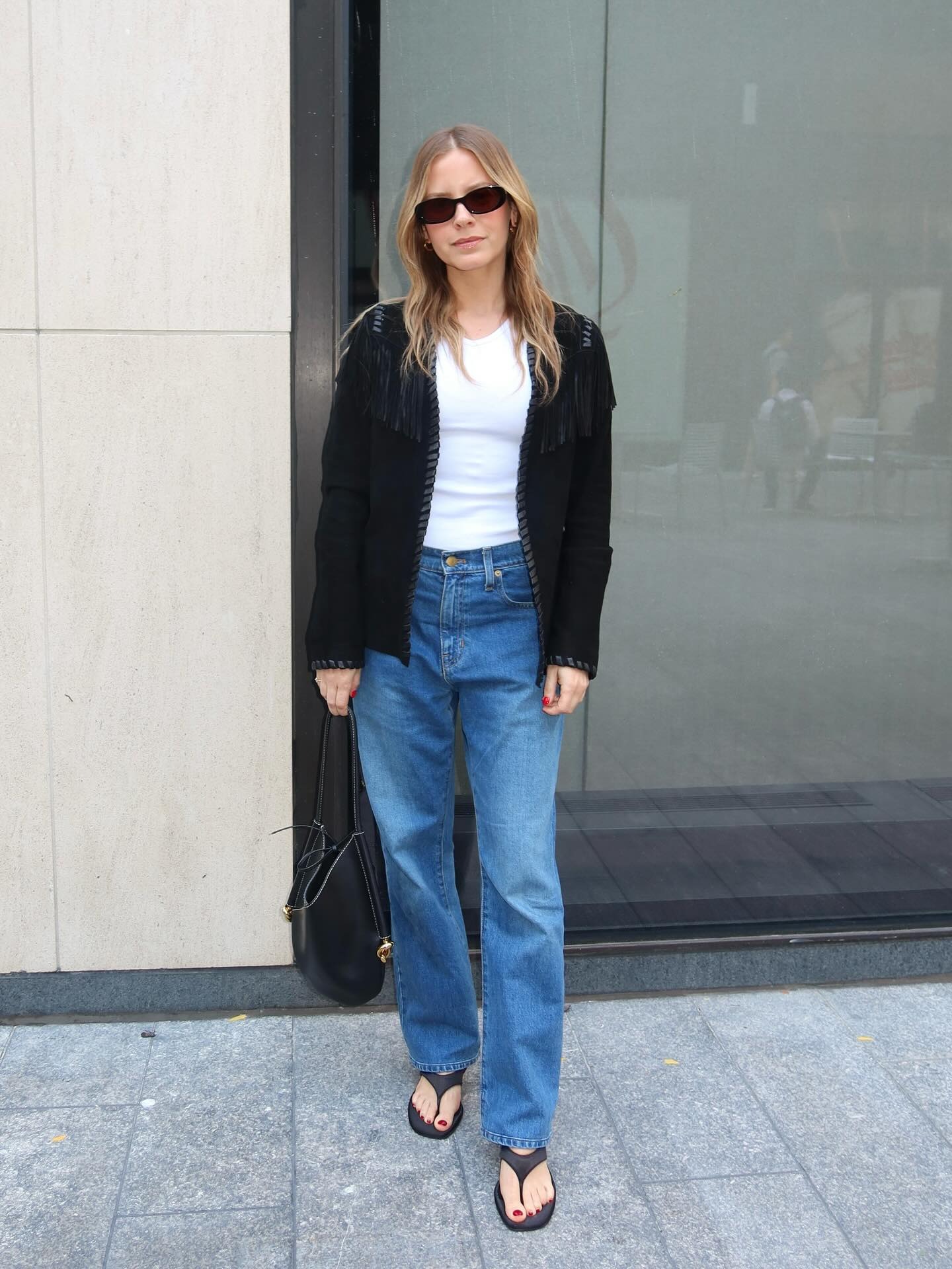 Nikki Chwatt wearing a light sweater over a white tee, jeans, and flip-flops.