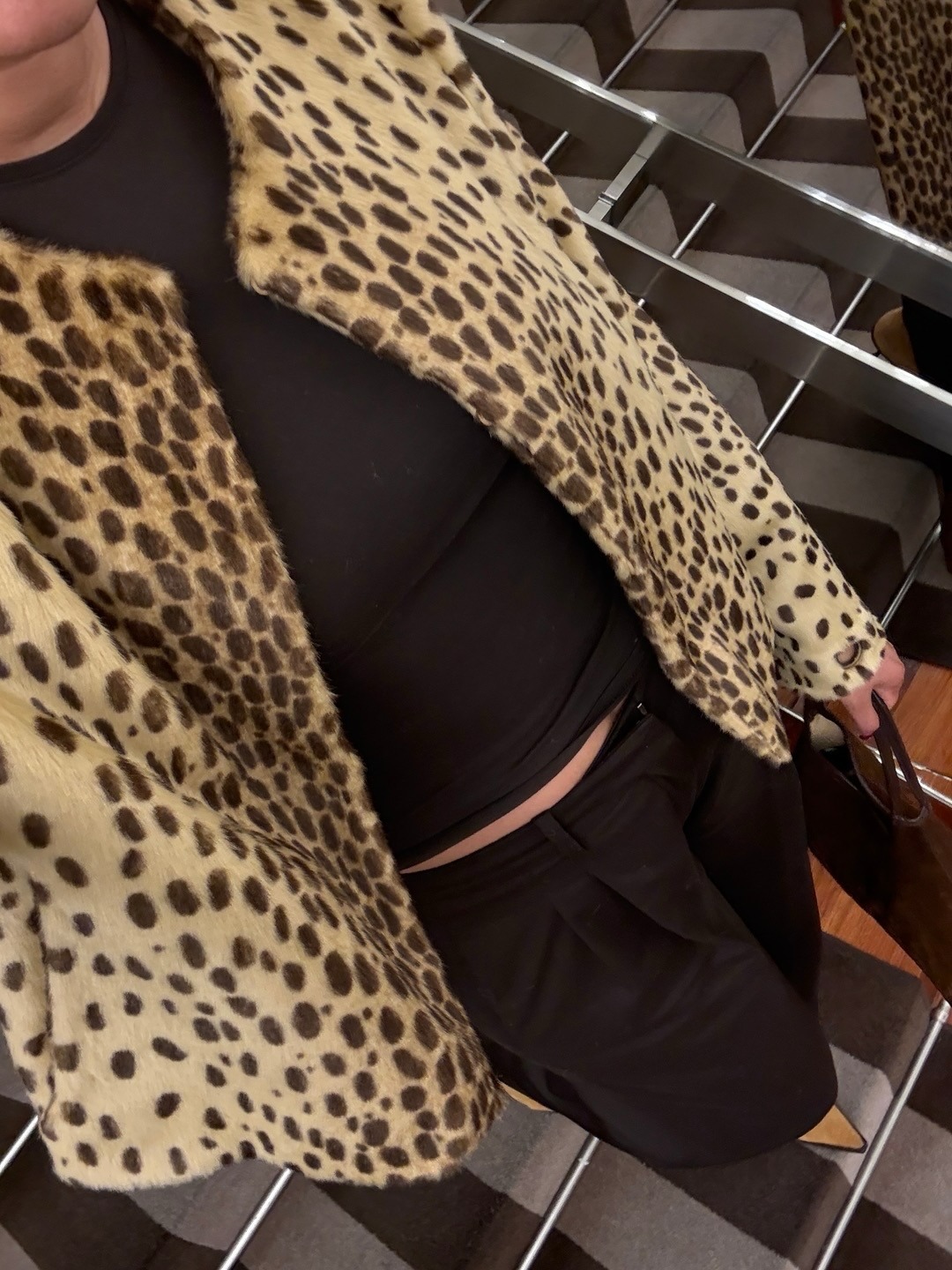 @lenafarl in an animal-print jacket, black trousers, and a black T-shirt.