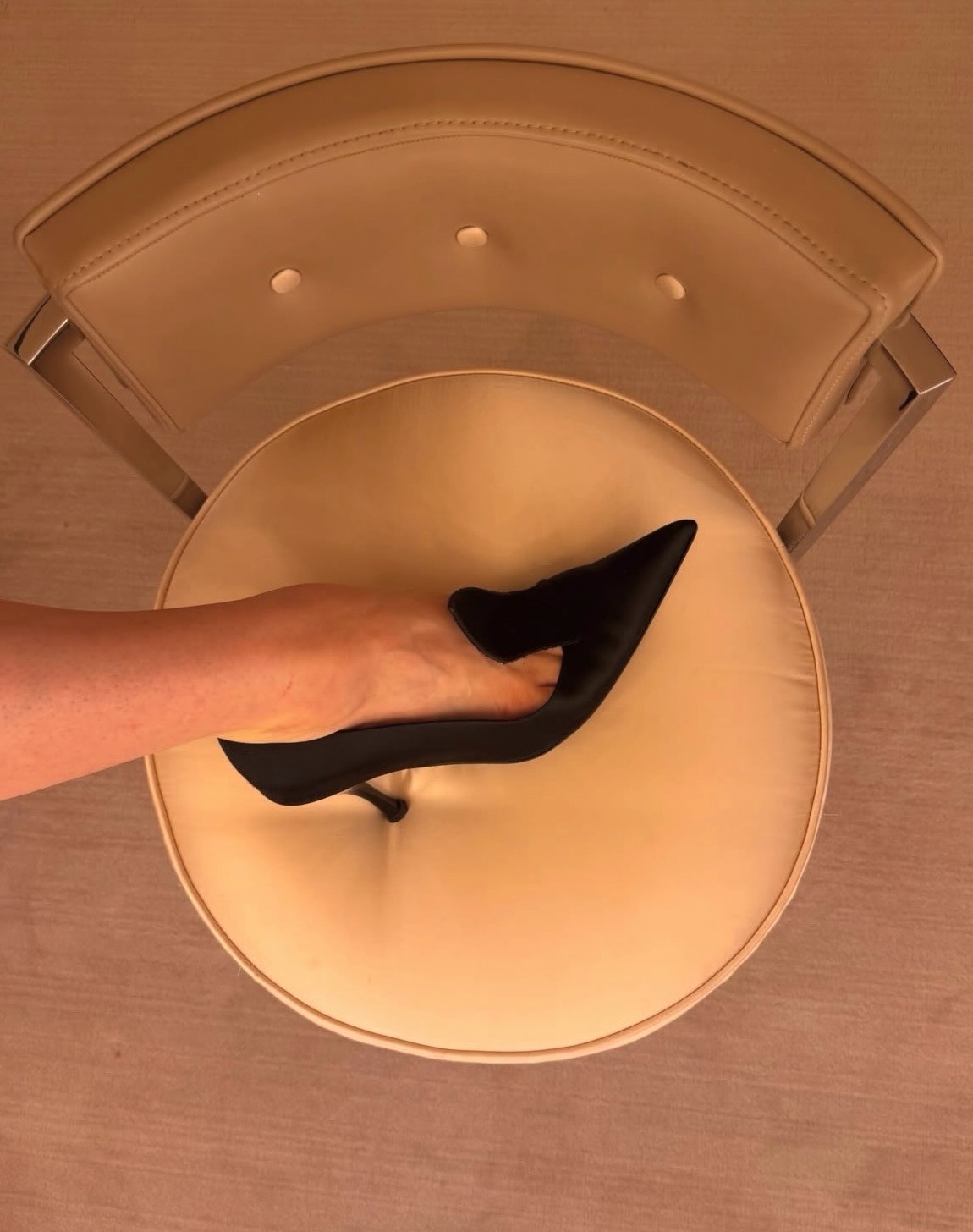 Woman wearing black satin opera heeled pumps.