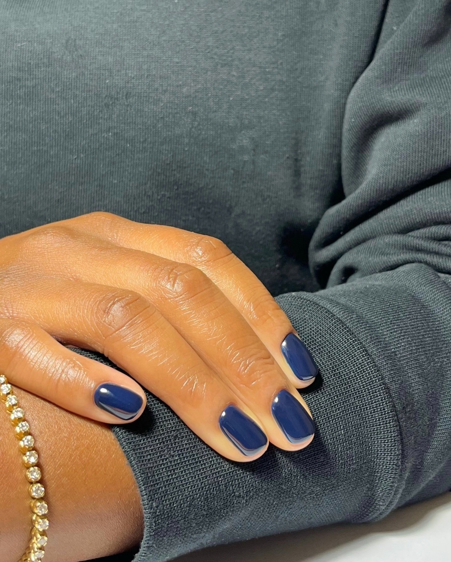 A close-up shot of a midnight blue manicure