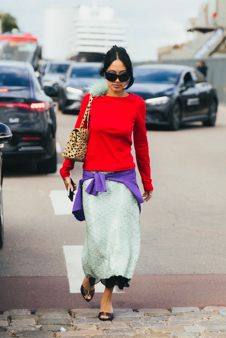 An image of an attendee at Copenhagen Fashion Week wearing the red and purple colour trend.