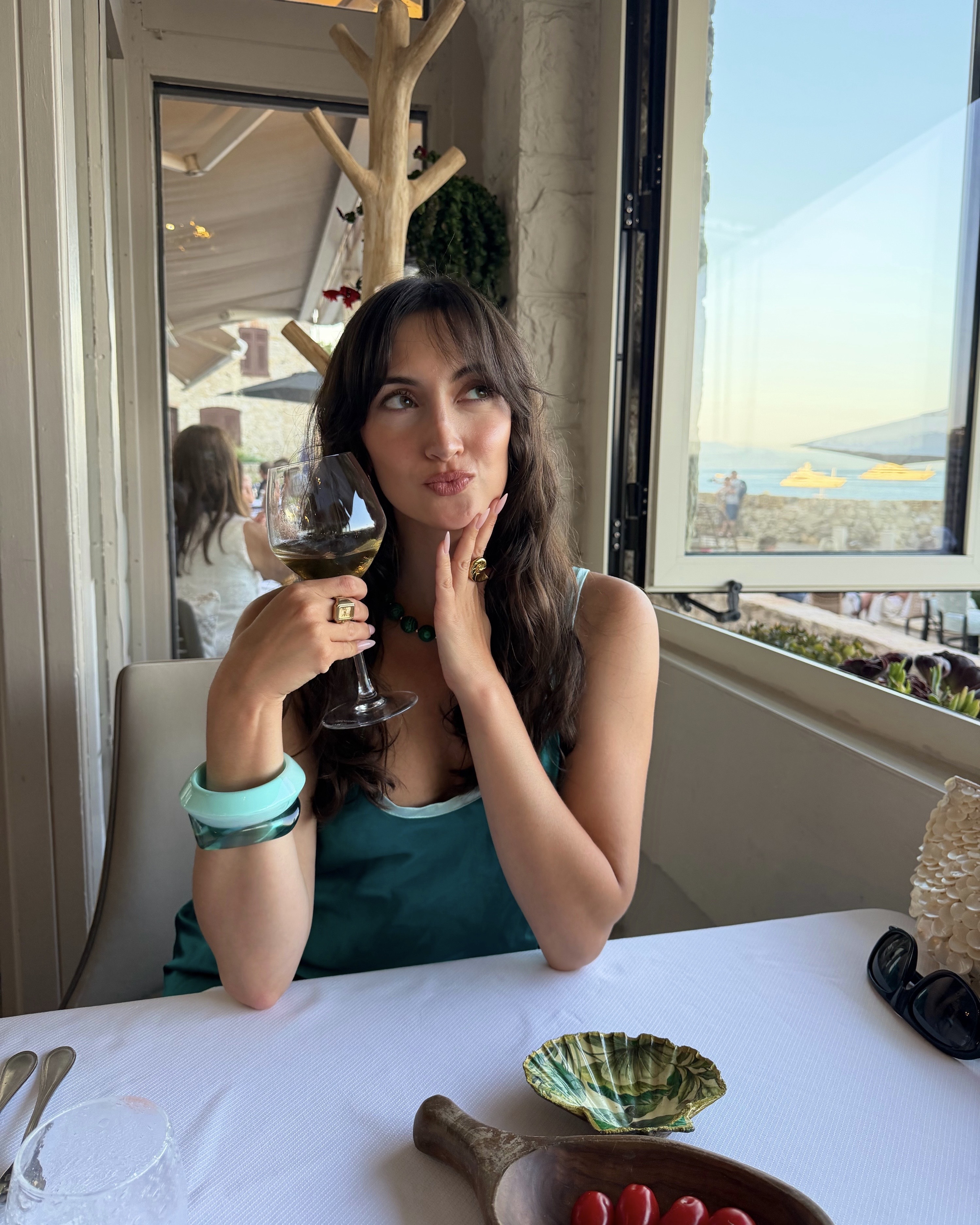 An image of Alyssa Brascia holding a wine glass at a restaurant in Antibes.