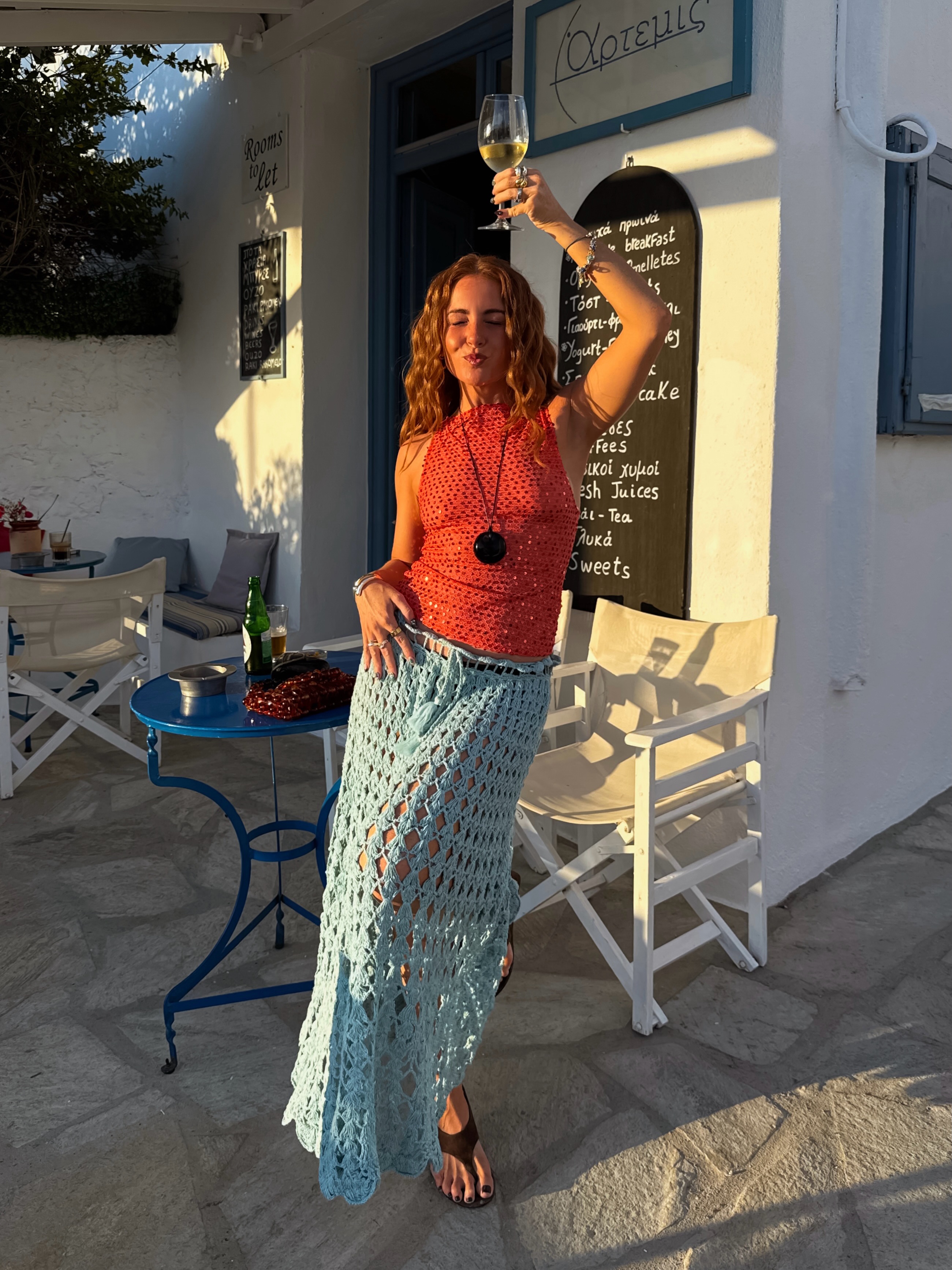 Influencer Rebecca Ferraz Wyatt wearing a tangerine sequin top, turquoise crochet skirt and cord necklace.