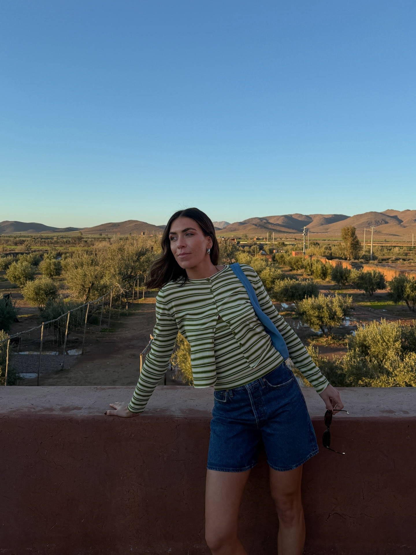 Influencer Jessica Skye wearing a striped cardigan and denim shorts.