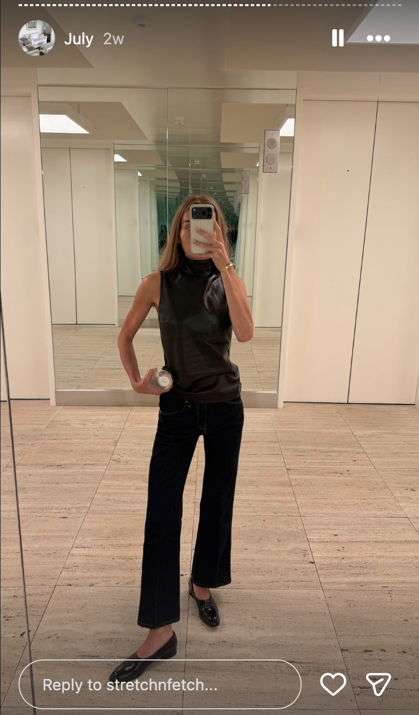 a woman wears black jeans and khaite colt loafers.